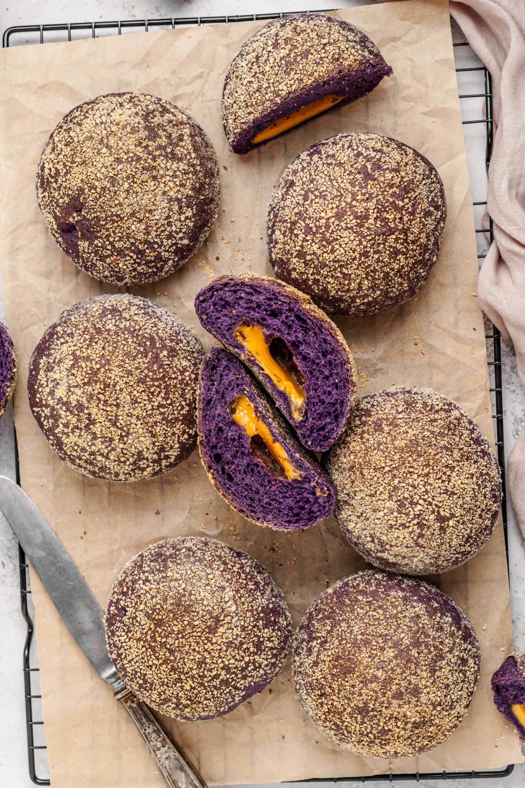 Ube Cheese Pandesal Stack - Catherine Zhang Stack of breadcrumb coated ube cheese pandesal rolls with one cut open