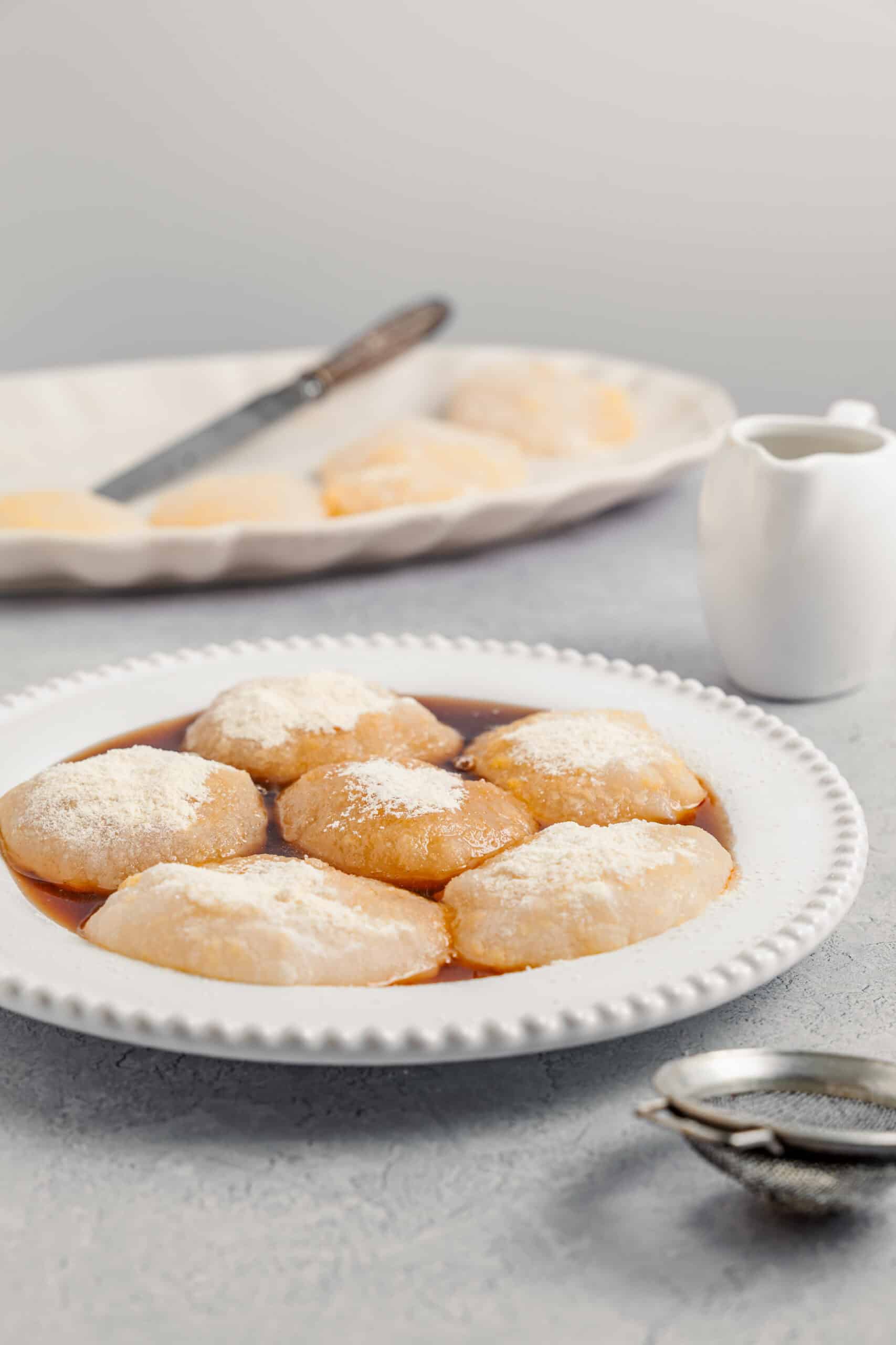 A plate of kinako dusted warabimochi with a small jug of kuromitsu alongside - Catherine Zhang A plate of kinako dusted warabimochi with a small jug of kuromitsu alongside