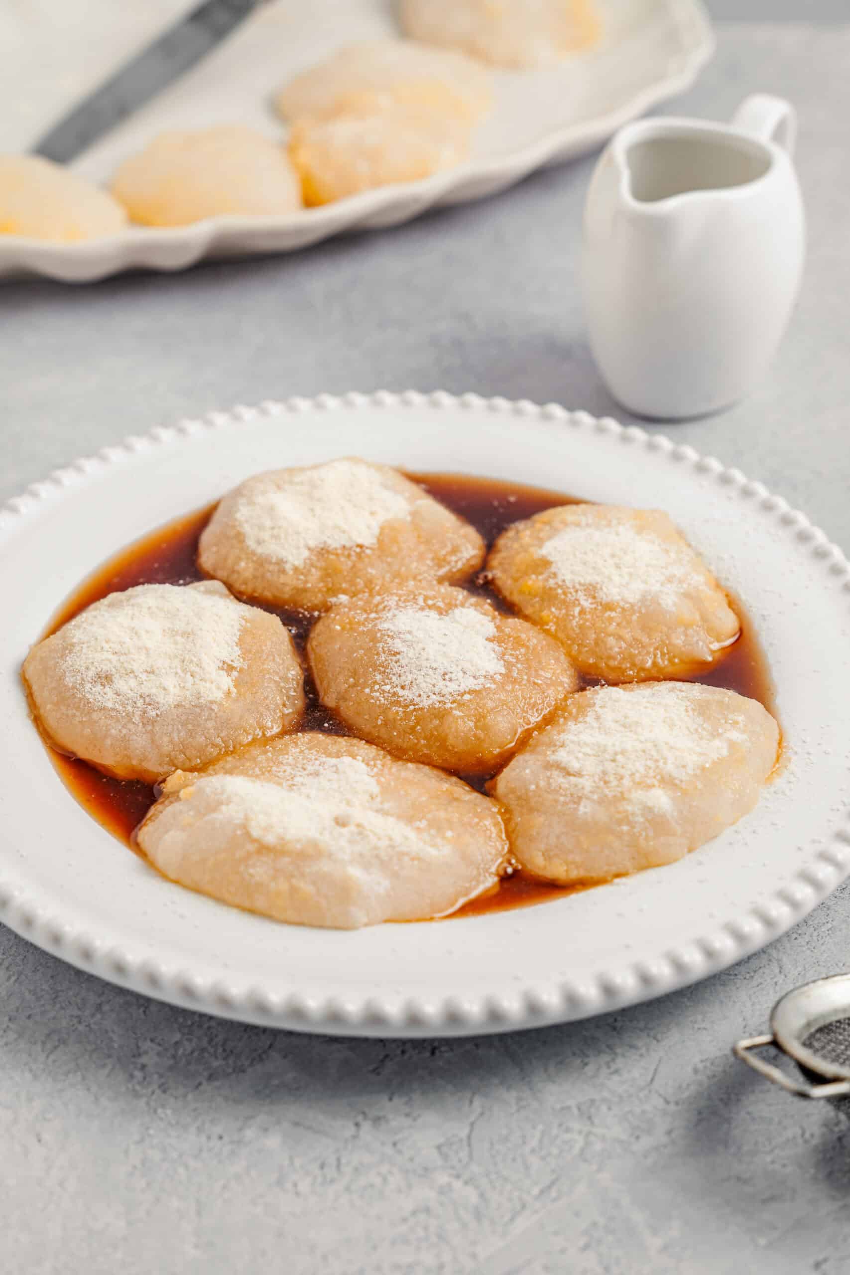 Warabimochi sitting in a pool of kuromitsu syrup, ready to eat - Catherine Zhang Warabimochi sitting in a pool of kuromitsu syrup, ready to eat