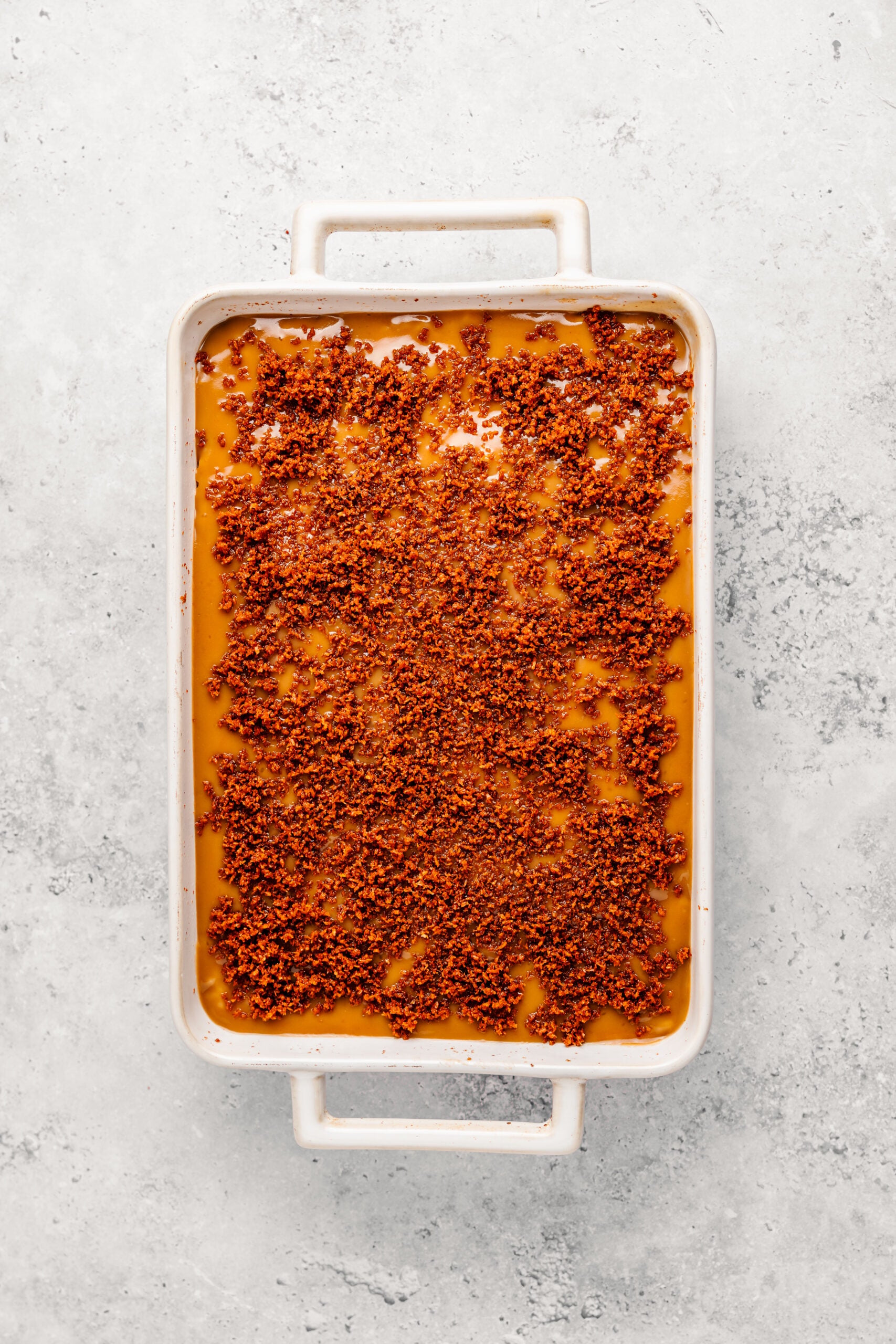 Crisp golden latik scattered over the glossy caramel top of Filipino biko - Catherine Zhang Crisp golden latik scattered over the glossy caramel top of Filipino biko