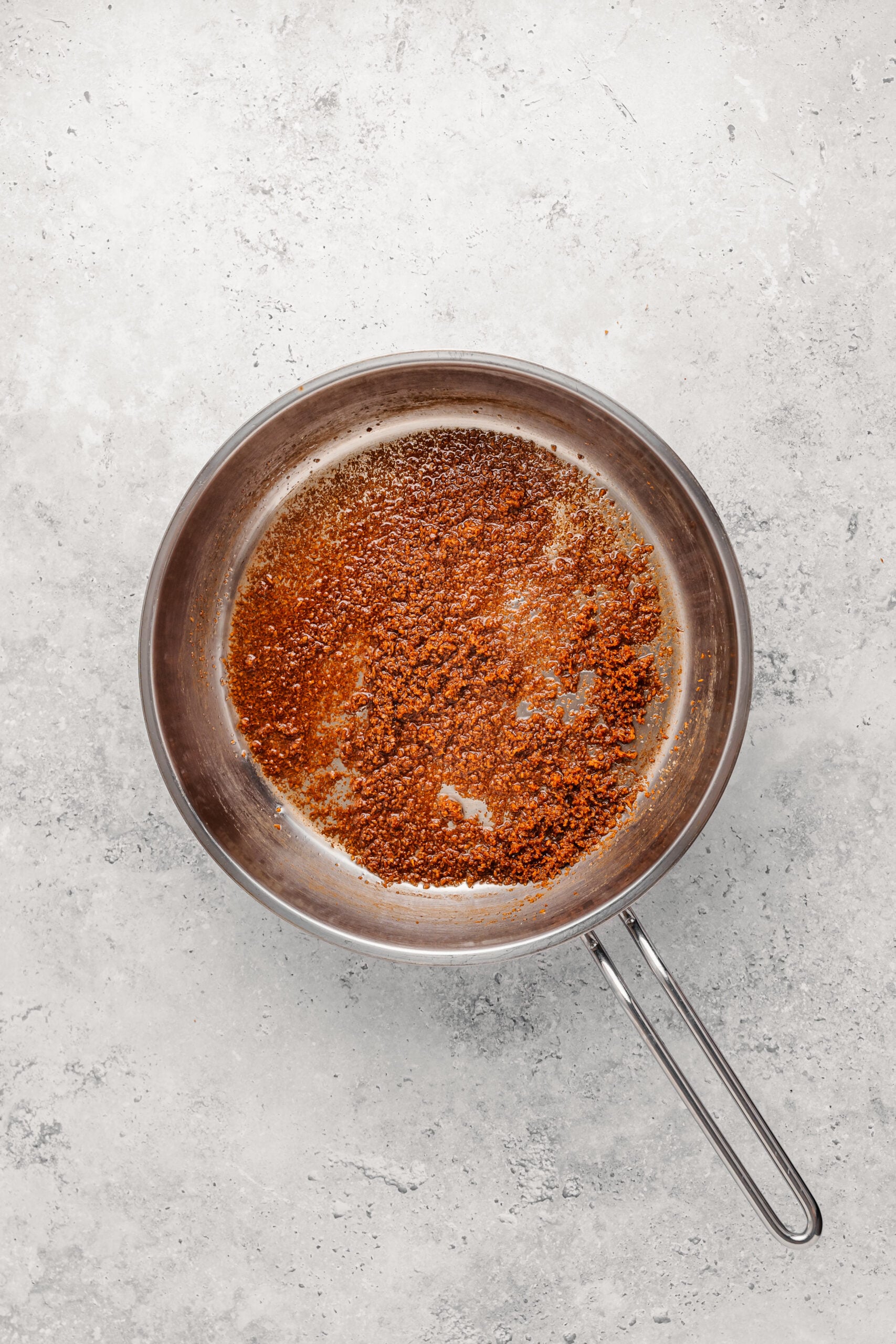 Coconut cream splitting into oil and pale solids in a pan while making latik for biko - Catherine Zhang Coconut cream splitting into oil and pale solids in a pan while making latik for biko