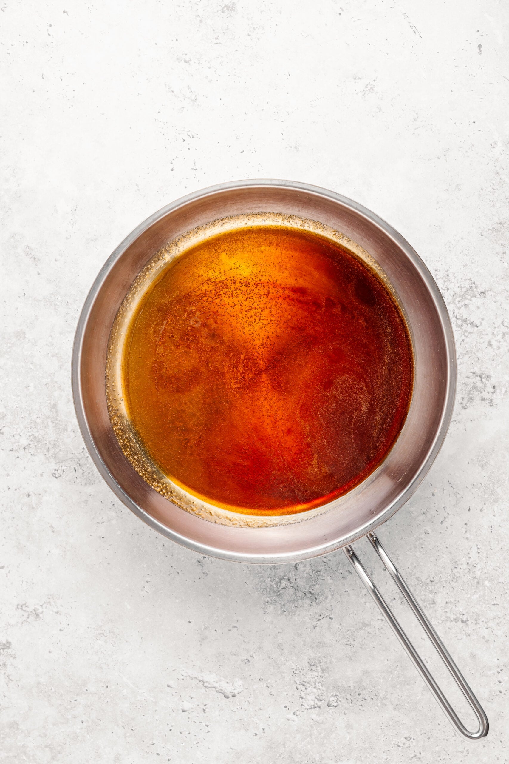 Smooth amber caramel in a dry frying pan for the turon caramel shell - Catherine Zhang Smooth amber caramel in a dry frying pan for the turon caramel shell