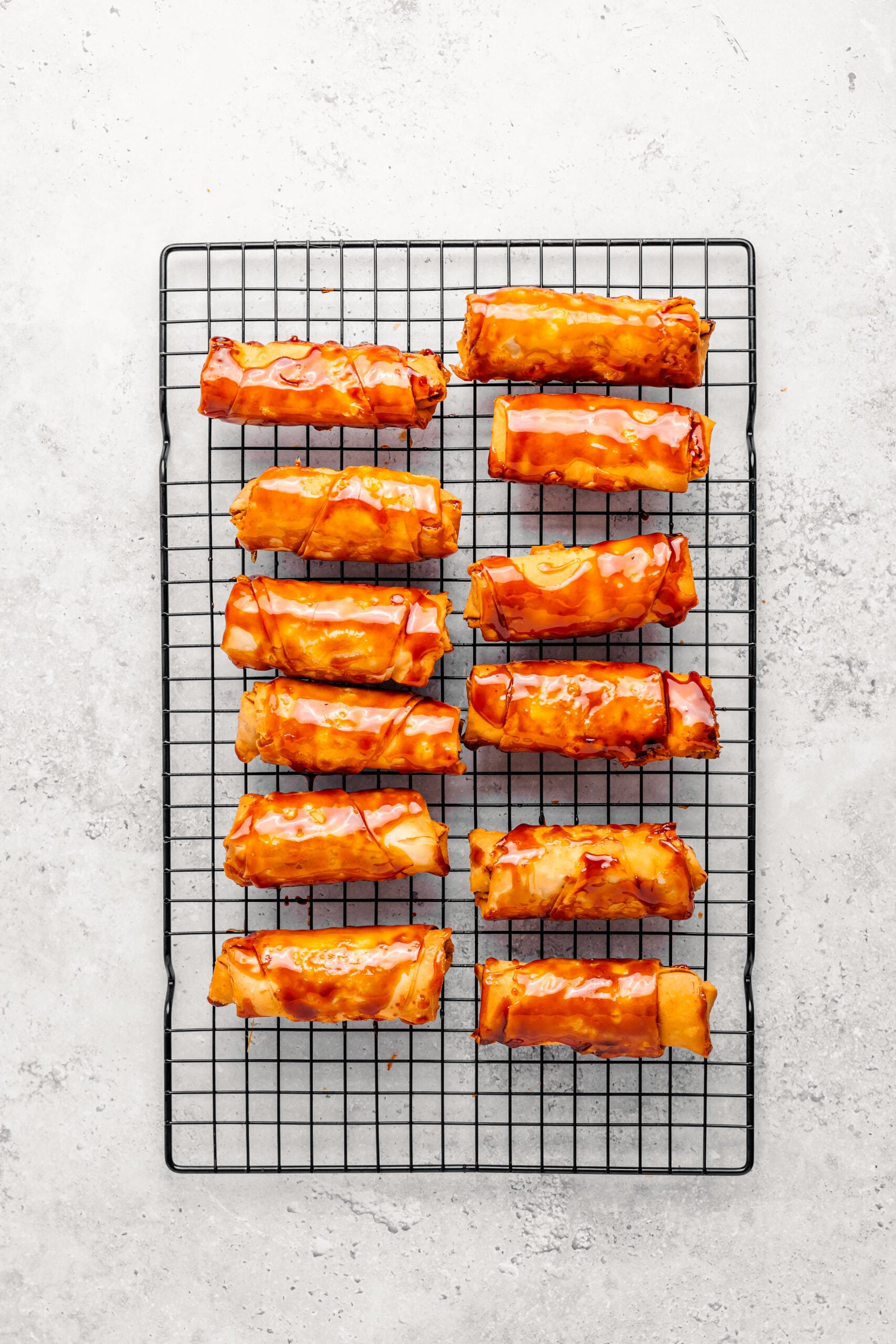 Freshly fried plain turon draining on a wire rack before the caramel step - Catherine Zhang Freshly fried plain turon draining on a wire rack before the caramel step