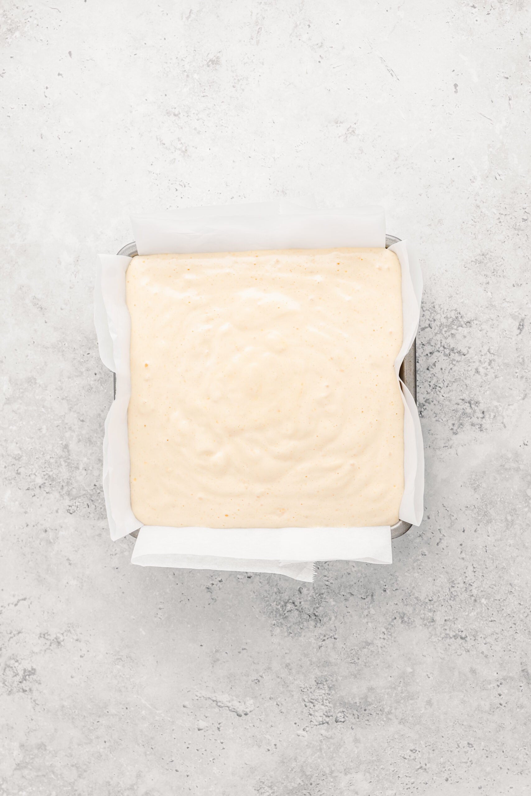 Japanese castella cake batter poured into the lined tin from a height - Catherine Zhang Japanese castella cake batter poured into the lined tin from a height