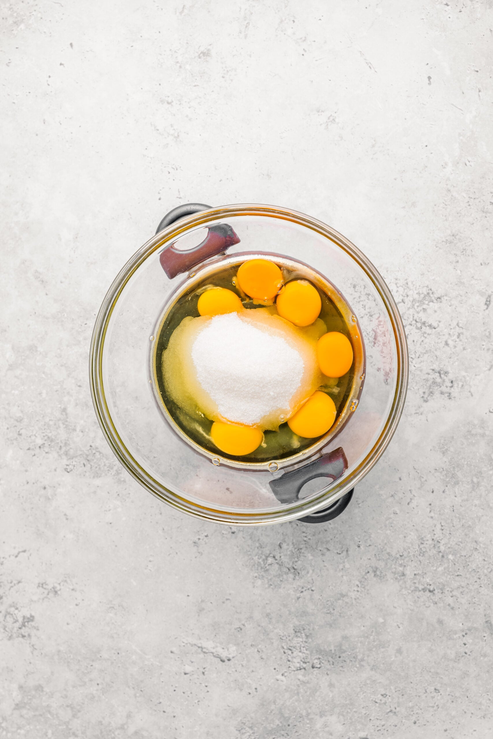 Eggs, caster sugar and salt in a glass bowl set over simmering water for castella - Catherine Zhang Eggs, caster sugar and salt in a glass bowl set over simmering water for castella