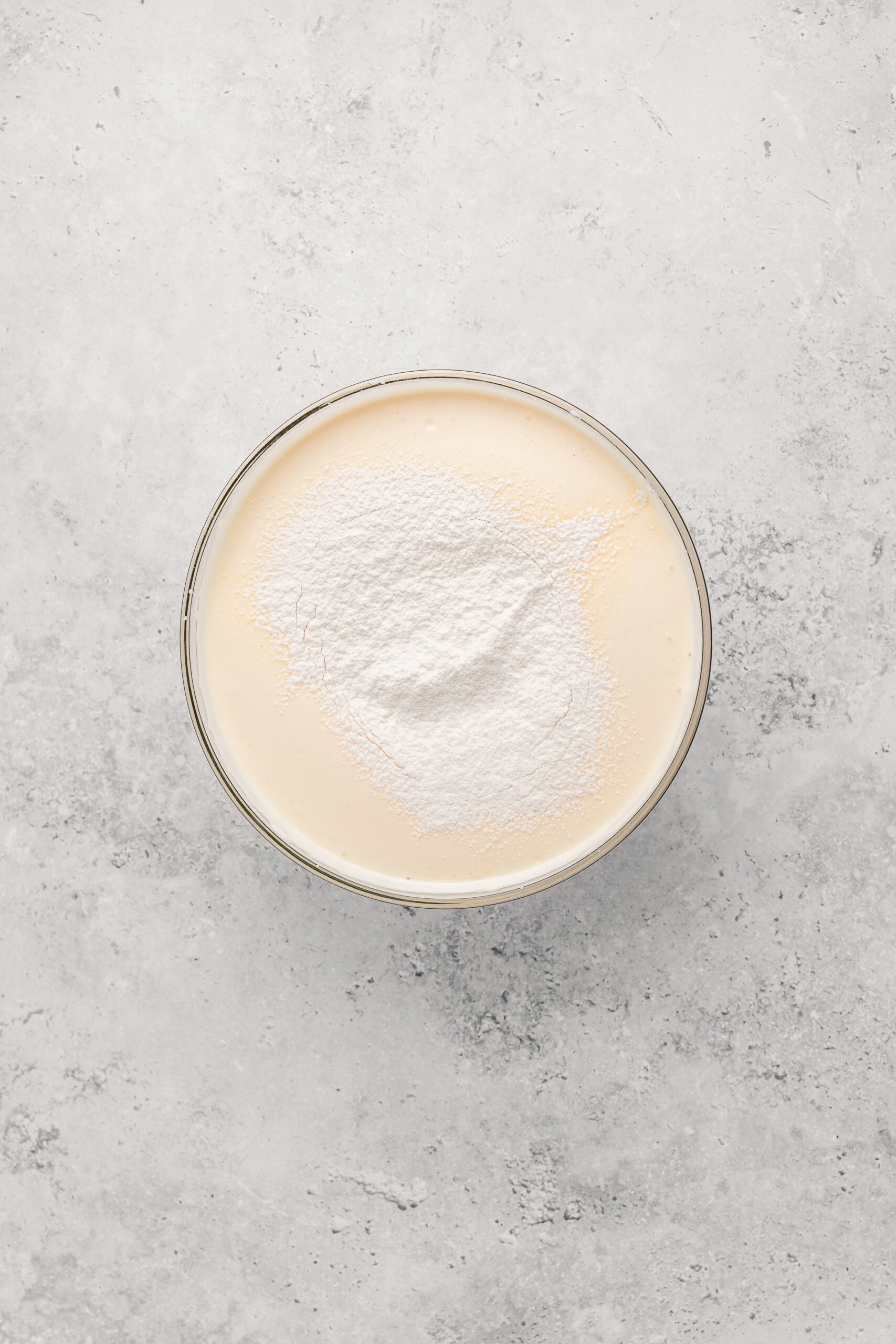 Sifted bread flour sitting on top of the whipped castella batter before folding - Catherine Zhang Sifted bread flour sitting on top of the whipped castella batter before folding