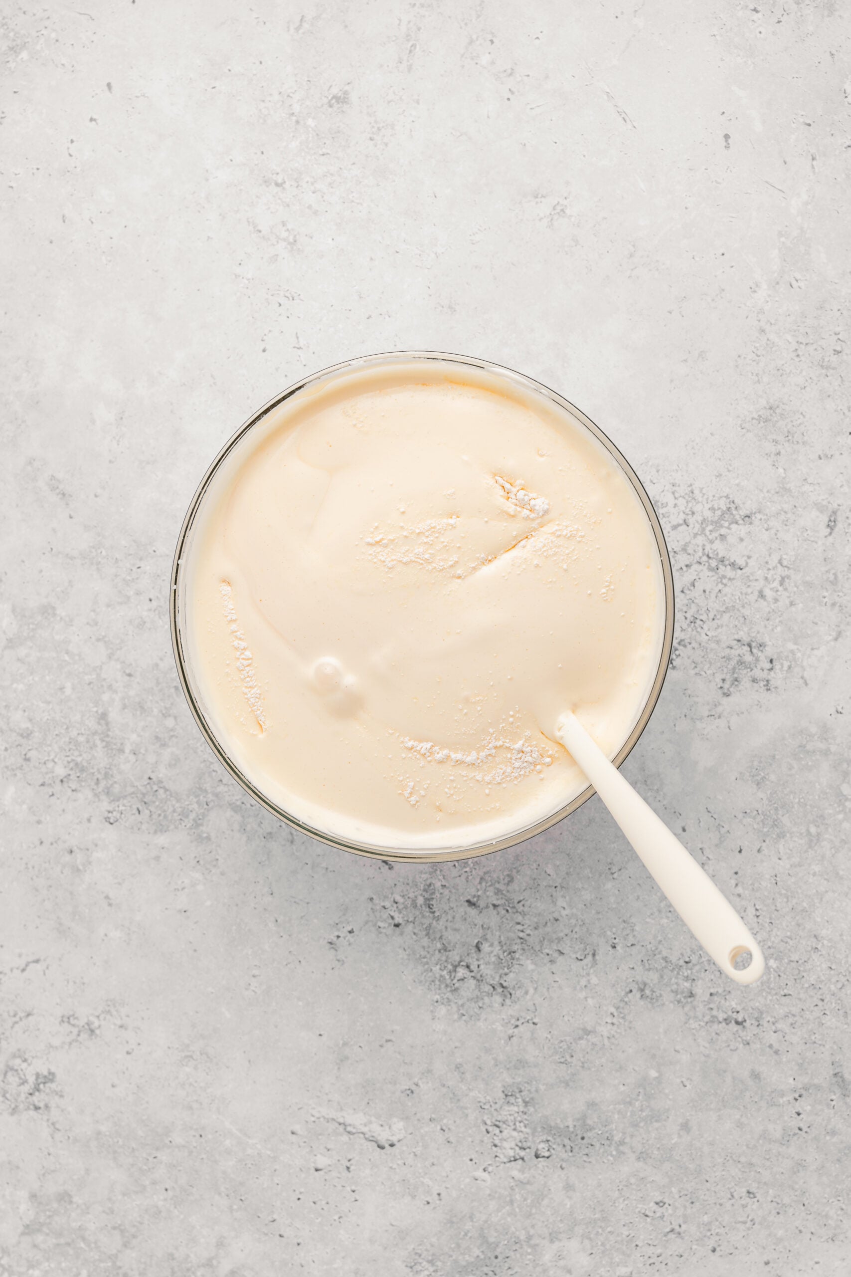 Folding sifted bread flour into Japanese castella cake batter with a spatula - Catherine Zhang Folding sifted bread flour into Japanese castella cake batter with a spatula