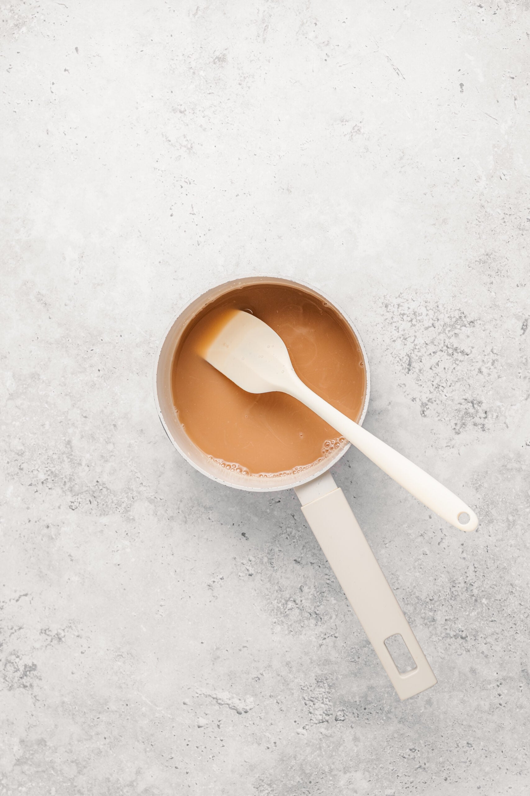 Warm honey and milk stirred together in a saucepan ready to fold into castella batter - Catherine Zhang Warm honey and milk stirred together in a saucepan ready to fold into castella batter