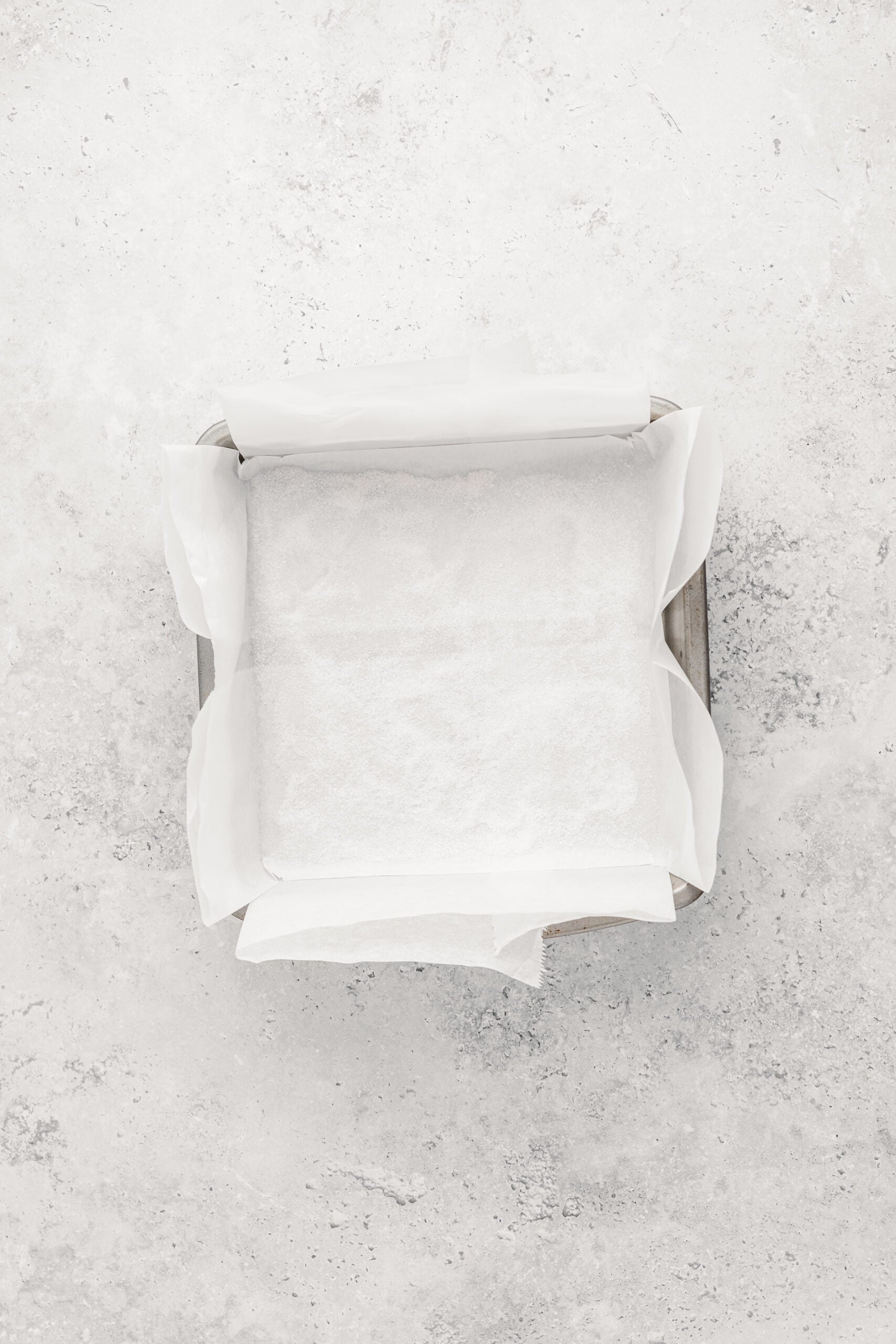 Baking tin lined with baking paper standing above the rim, ready for Japanese castella cake batter - Catherine Zhang Baking tin lined with baking paper standing above the rim, ready for Japanese castella cake batter