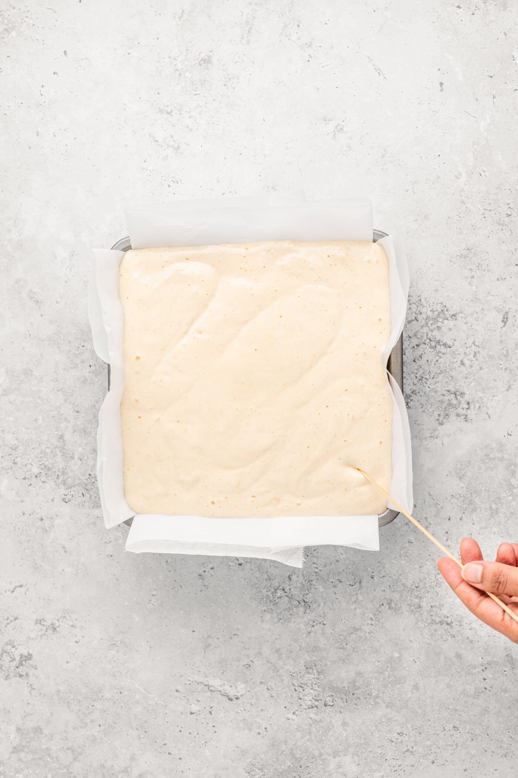 Dragging a skewer through Japanese castella cake batter in a zigzag to burst large bubbles - Catherine Zhang Dragging a skewer through Japanese castella cake batter in a zigzag to burst large bubbles