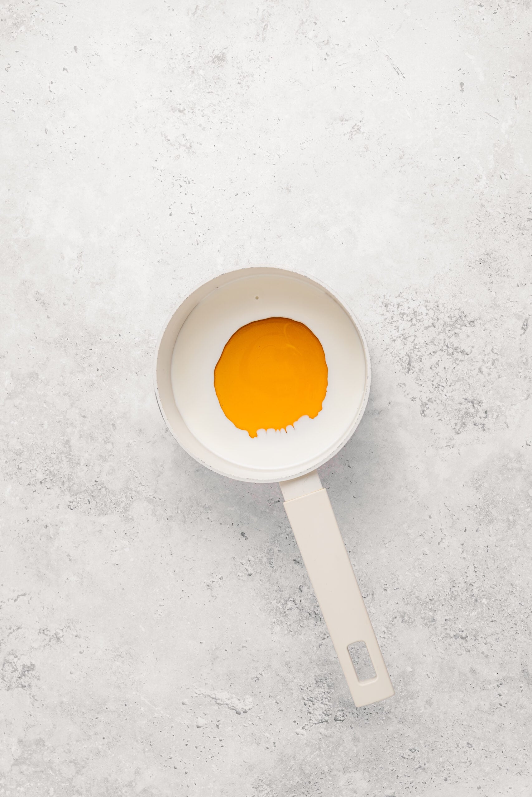 Honey warming in a small saucepan for Japanese castella cake - Catherine Zhang Honey warming in a small saucepan for Japanese castella cake