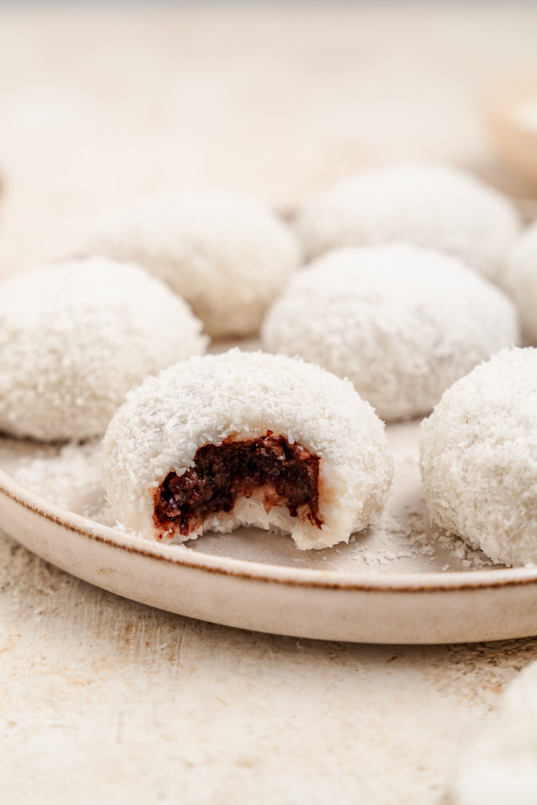 Red bean mochi with a bite taken showing the sweet adzuki filling - Catherine Zhang Red bean mochi with a bite taken showing the sweet adzuki filling