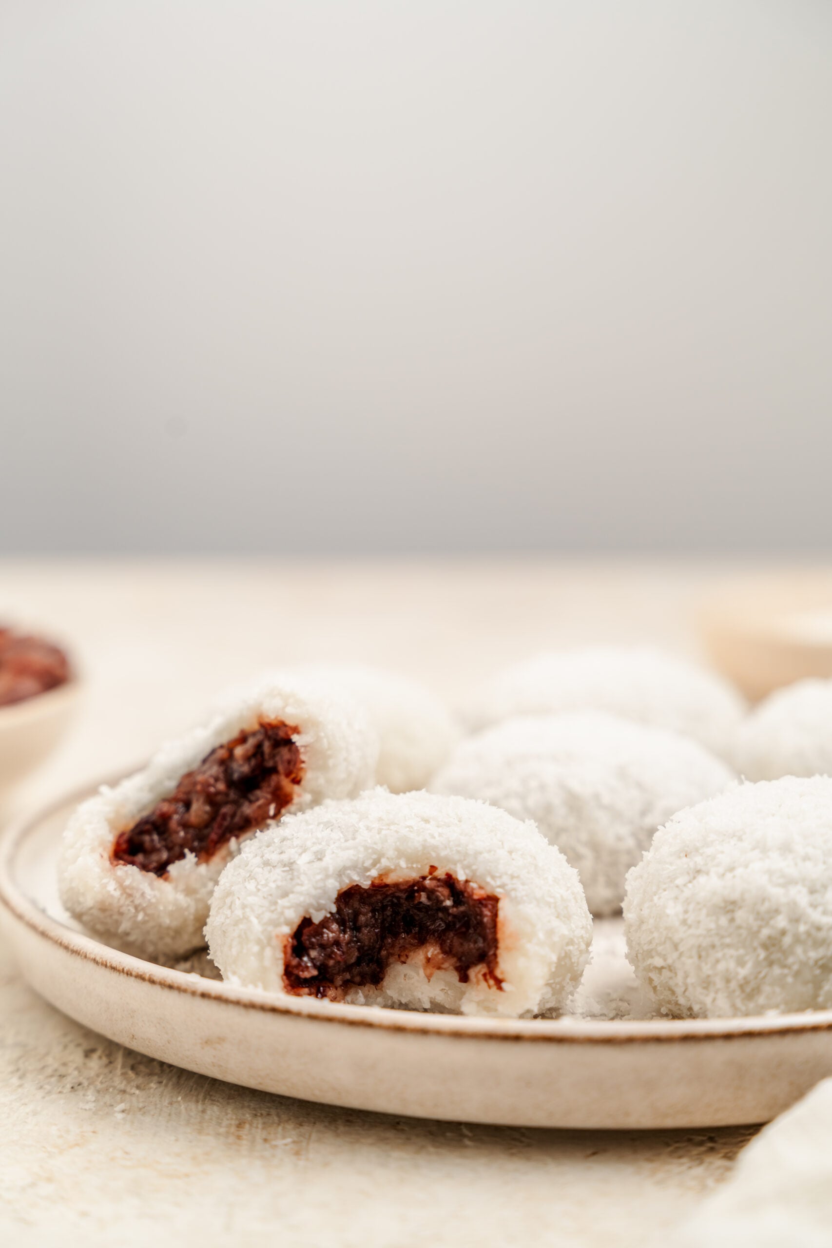 Red bean mochi cut open showing the dark red bean paste centre - Catherine Zhang Red bean mochi cut open showing the dark red bean paste centre