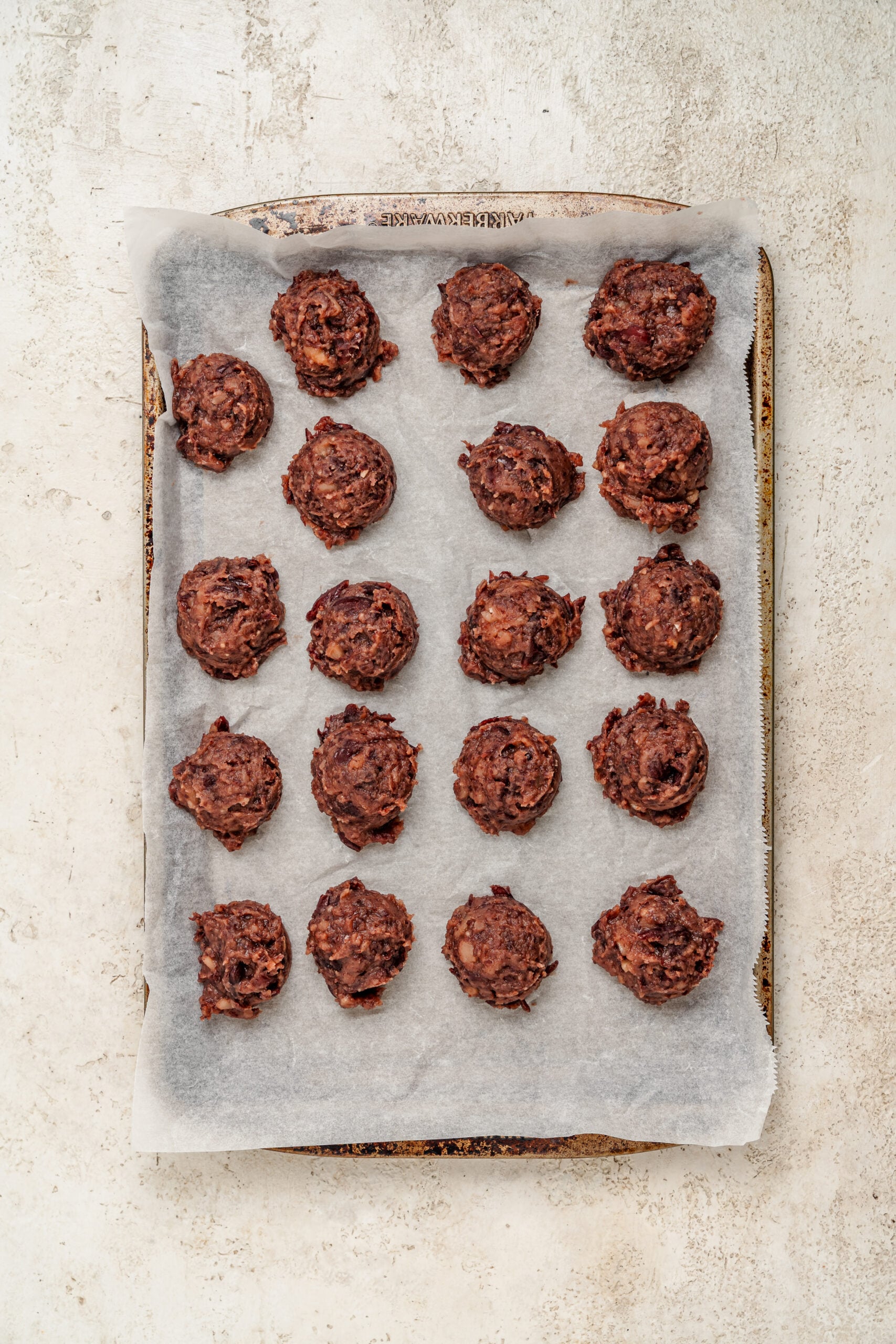 Sweet red bean paste rolled into balls on a lined tray for red bean mochi - Catherine Zhang Sweet red bean paste rolled into balls on a lined tray for red bean mochi