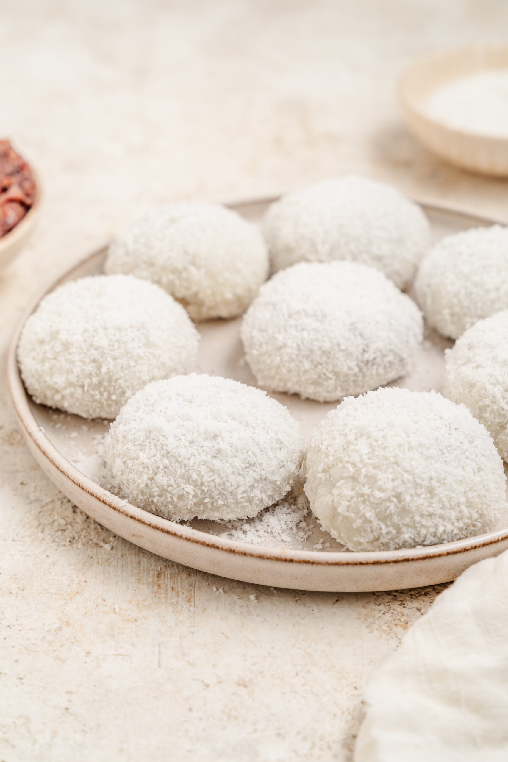 A plate of red bean mochi coated in desiccated coconut - Catherine Zhang A plate of red bean mochi coated in desiccated coconut