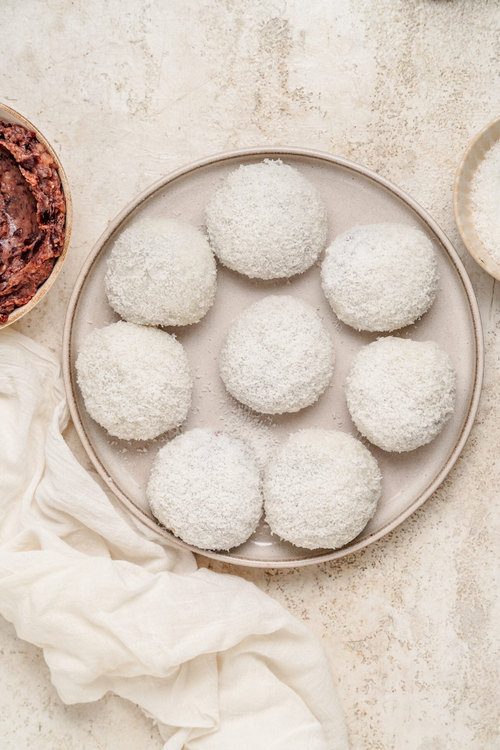 Overhead plate of red bean mochi with sweet red bean paste alongside - Catherine Zhang Overhead plate of red bean mochi with sweet red bean paste alongside