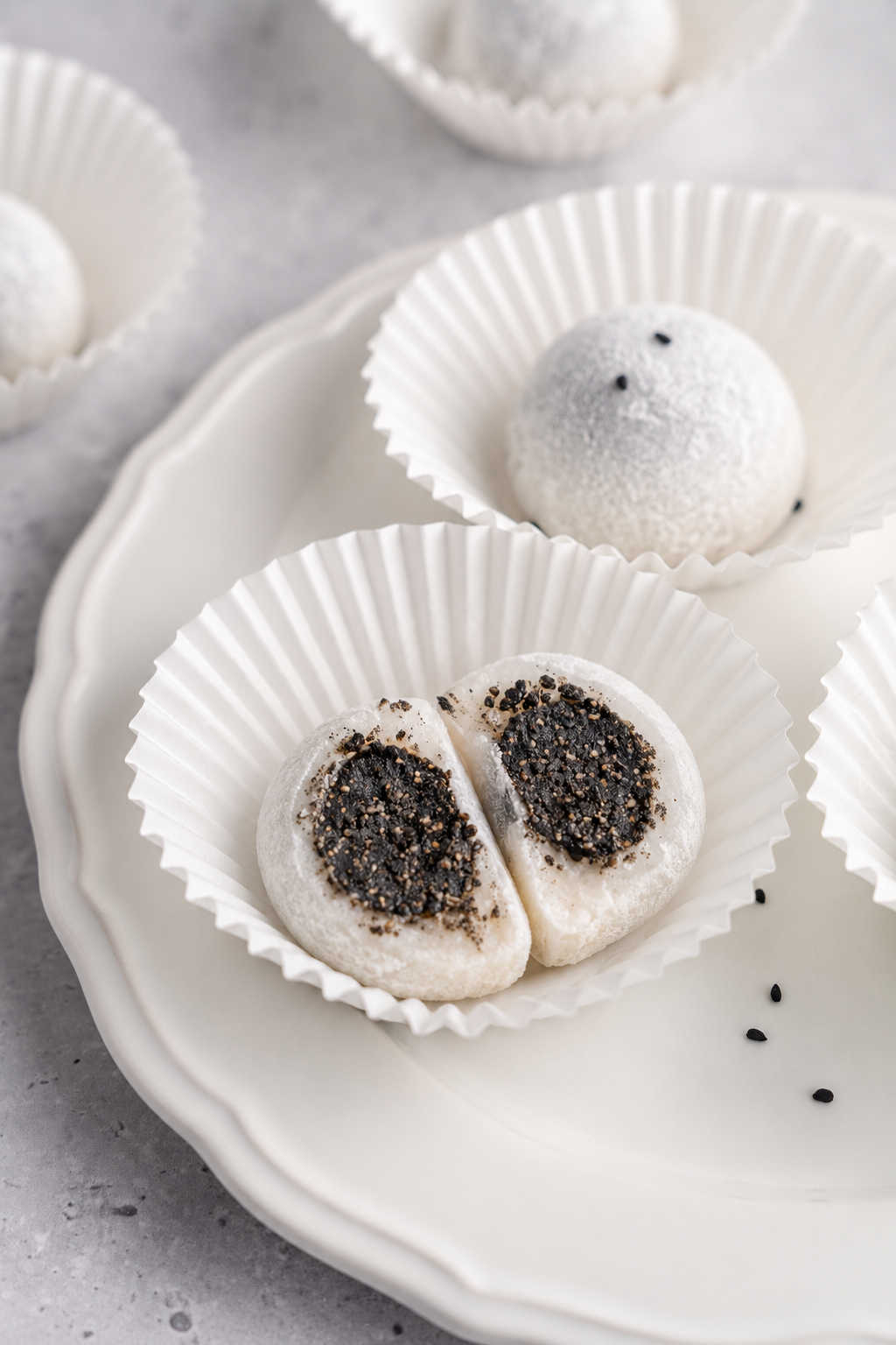 Black sesame mochi cross section - Catherine Zhang Close view of a halved black sesame mochi with a thick dark filling