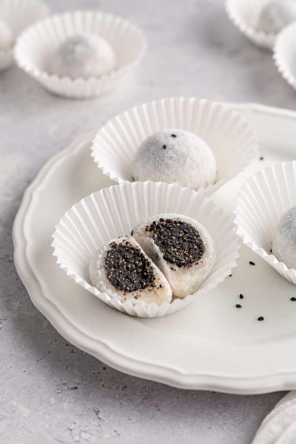 Black sesame mochi cut open - Catherine Zhang A black sesame mochi cut open showing the dark sesame filling inside