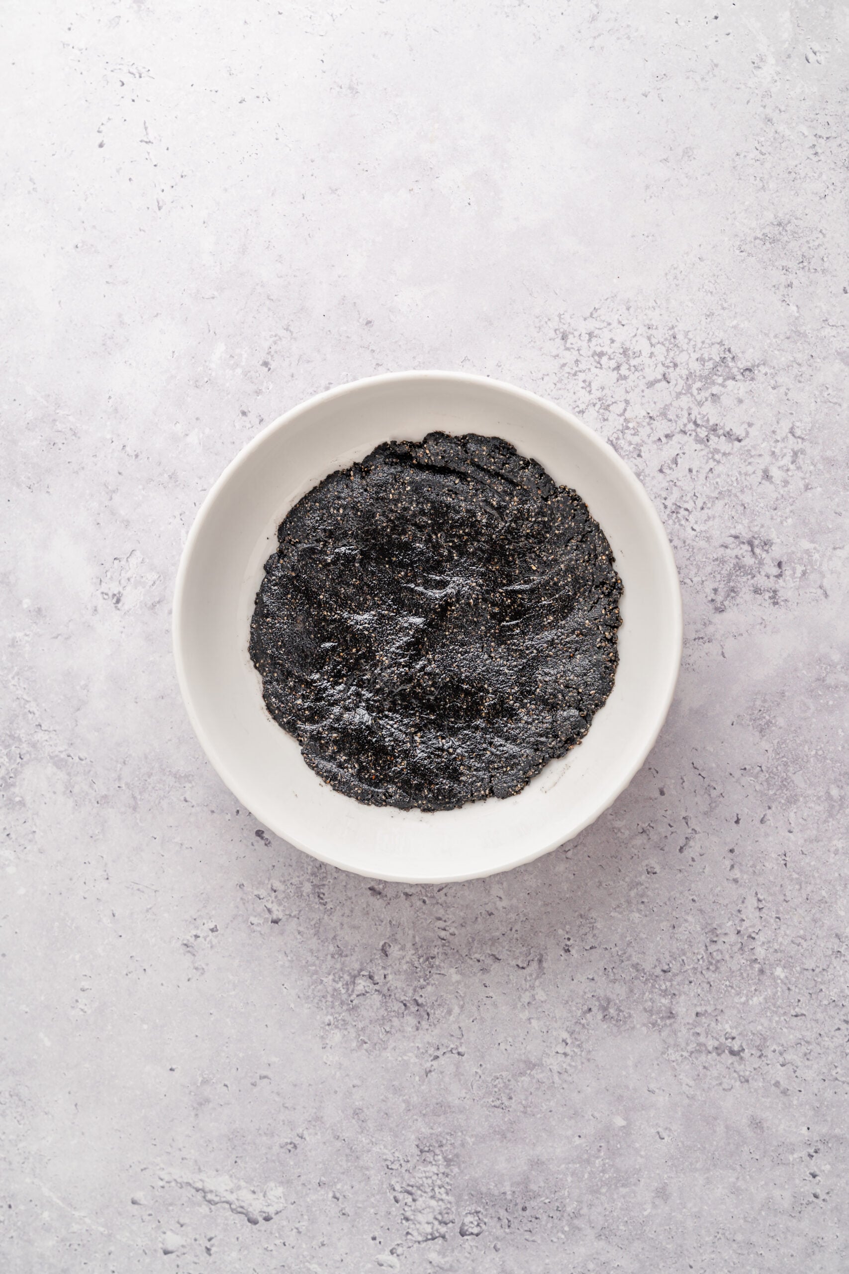 Black sesame filling chilling - Catherine Zhang Thick black sesame filling scraped into a white bowl ready to chill