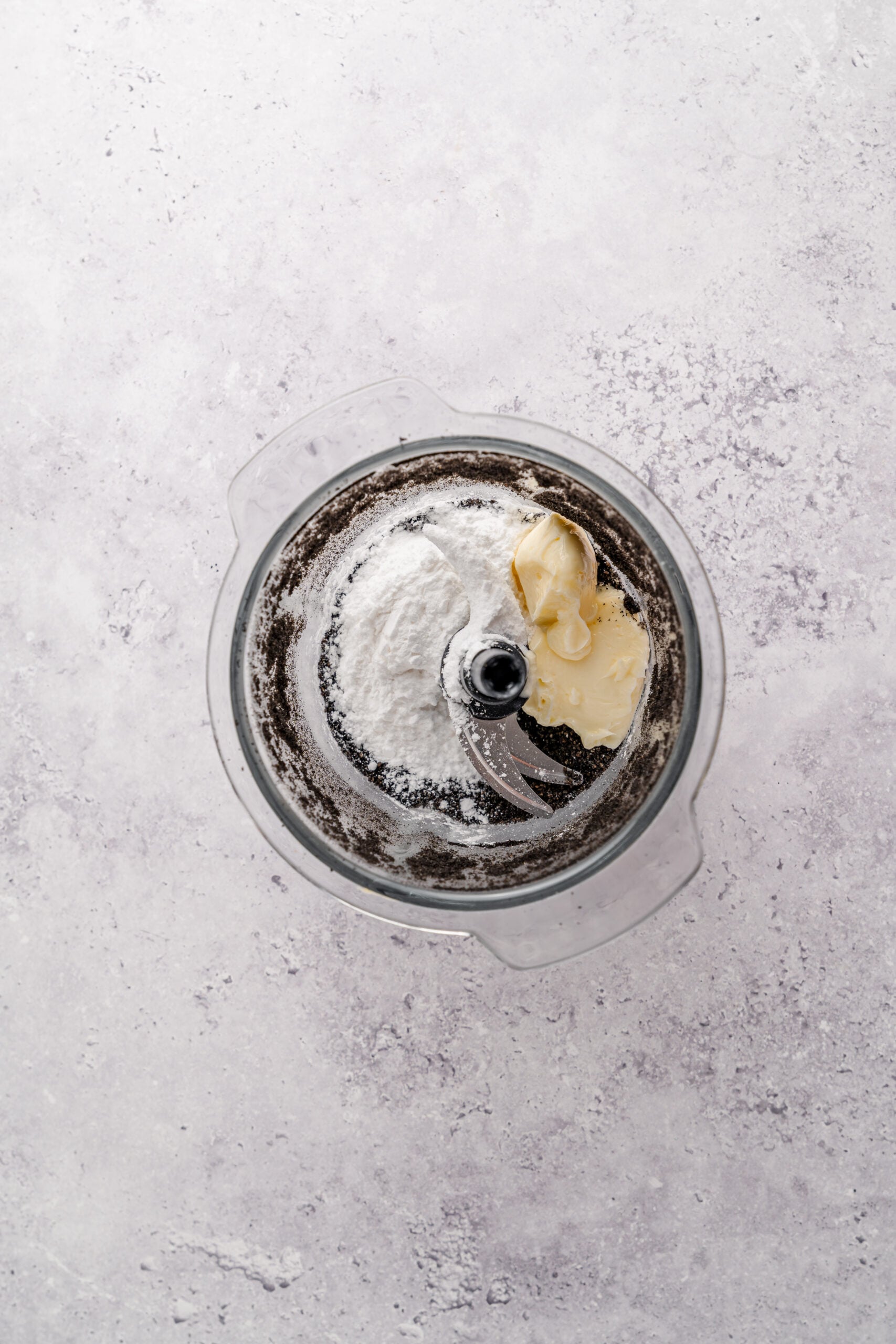Black sesame filling in the food processor - Catherine Zhang Powdered sugar and softened butter added to ground black sesame in a food processor