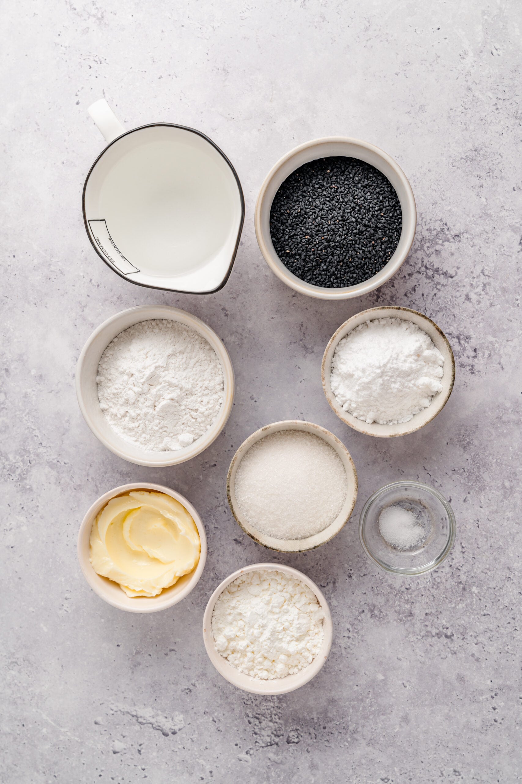 Black sesame mochi ingredients - Catherine Zhang Ingredients for black sesame mochi measured into small bowls on a grey surface