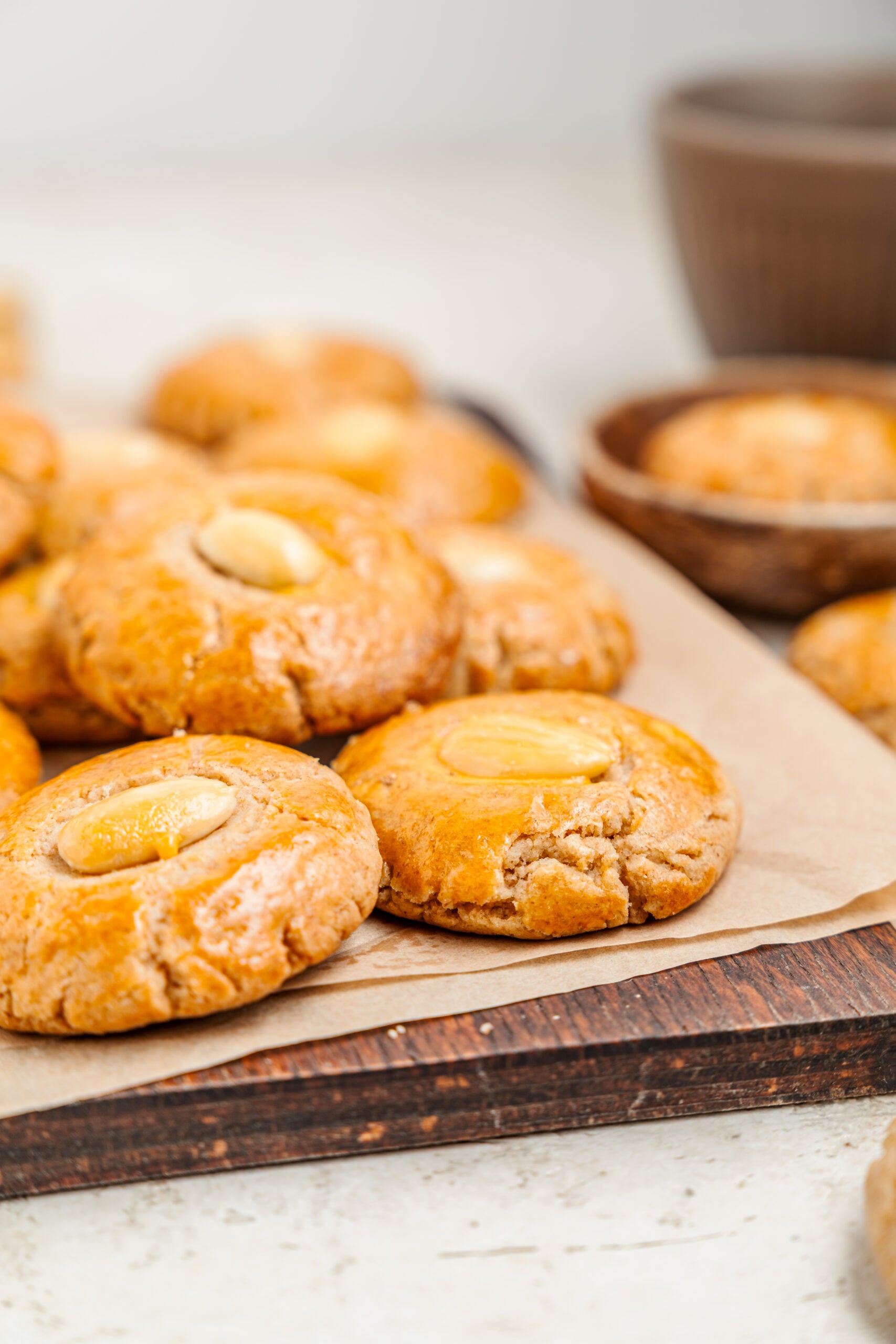 Chinese Almond Cookies - Catherine Zhang Chinese almond cookies with a whole almond in the centre of each, piled on baking paper