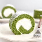 Matcha roll cake slice showing a tight cream spiral inside a green sponge