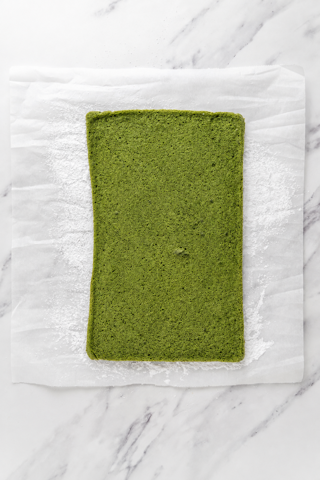 Baked matcha sponge - Catherine Zhang Baked matcha sponge turned out onto sugar dusted parchment