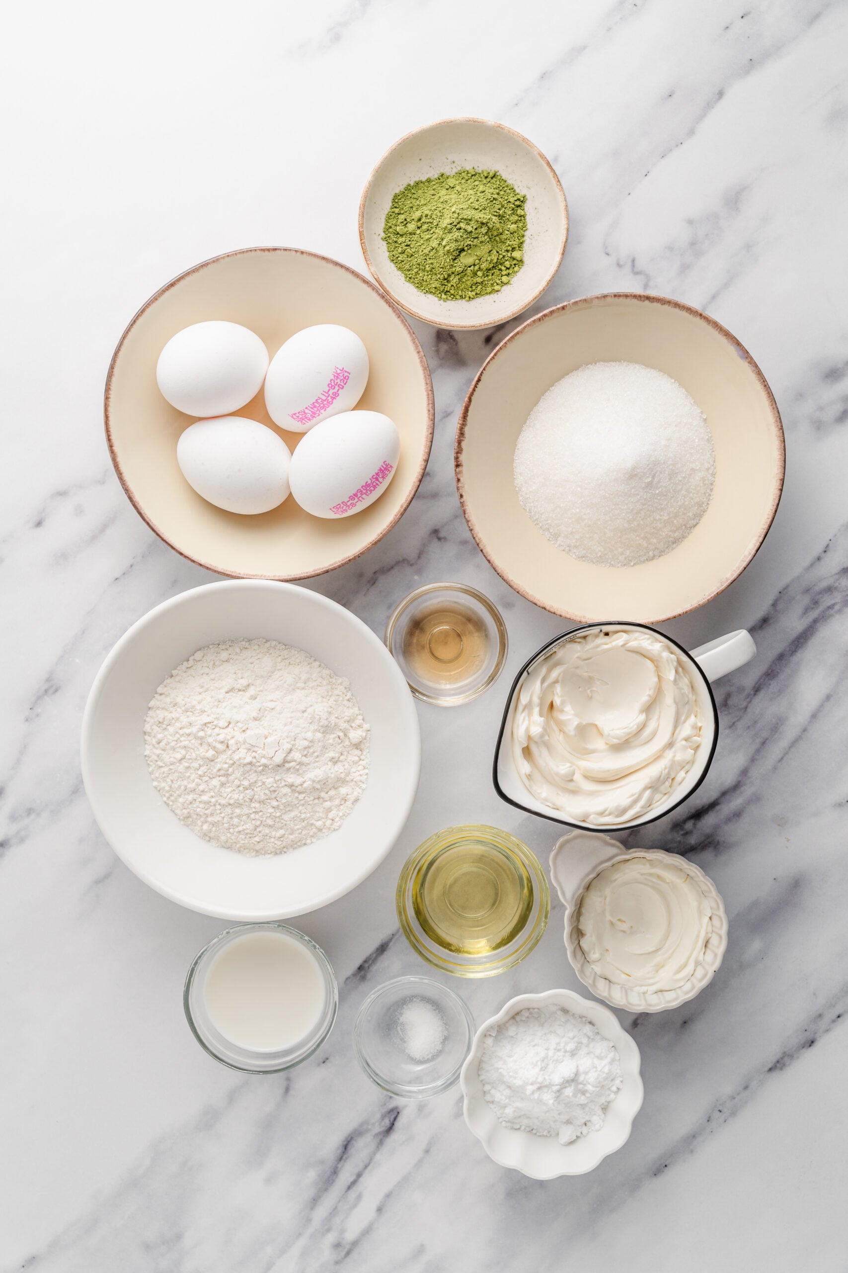 Matcha roll cake ingredients - Catherine Zhang Ingredients for matcha roll cake measured into bowls on white marble