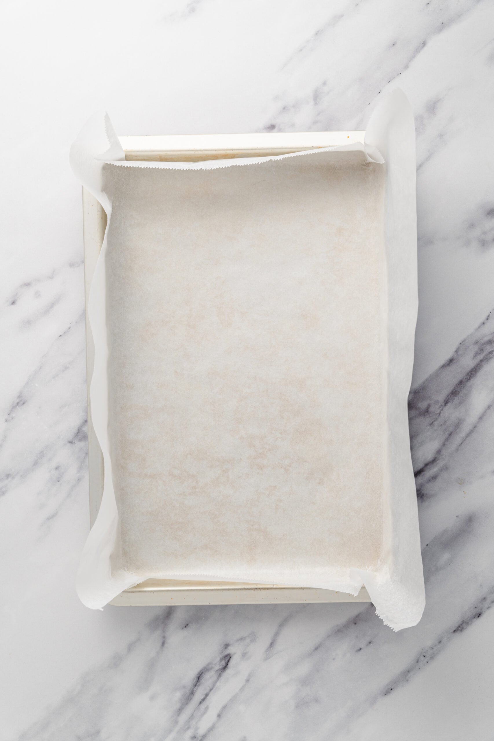 Lined jelly roll pan - Catherine Zhang A jelly roll pan lined with parchment paper for the matcha sponge