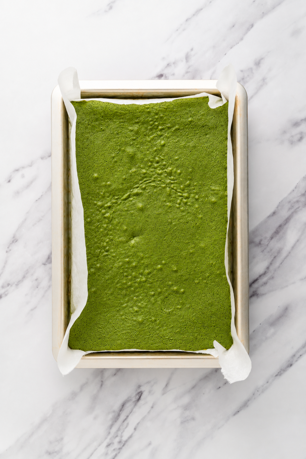 Ready to bake - Catherine Zhang Matcha sponge batter tapped level and ready for the oven