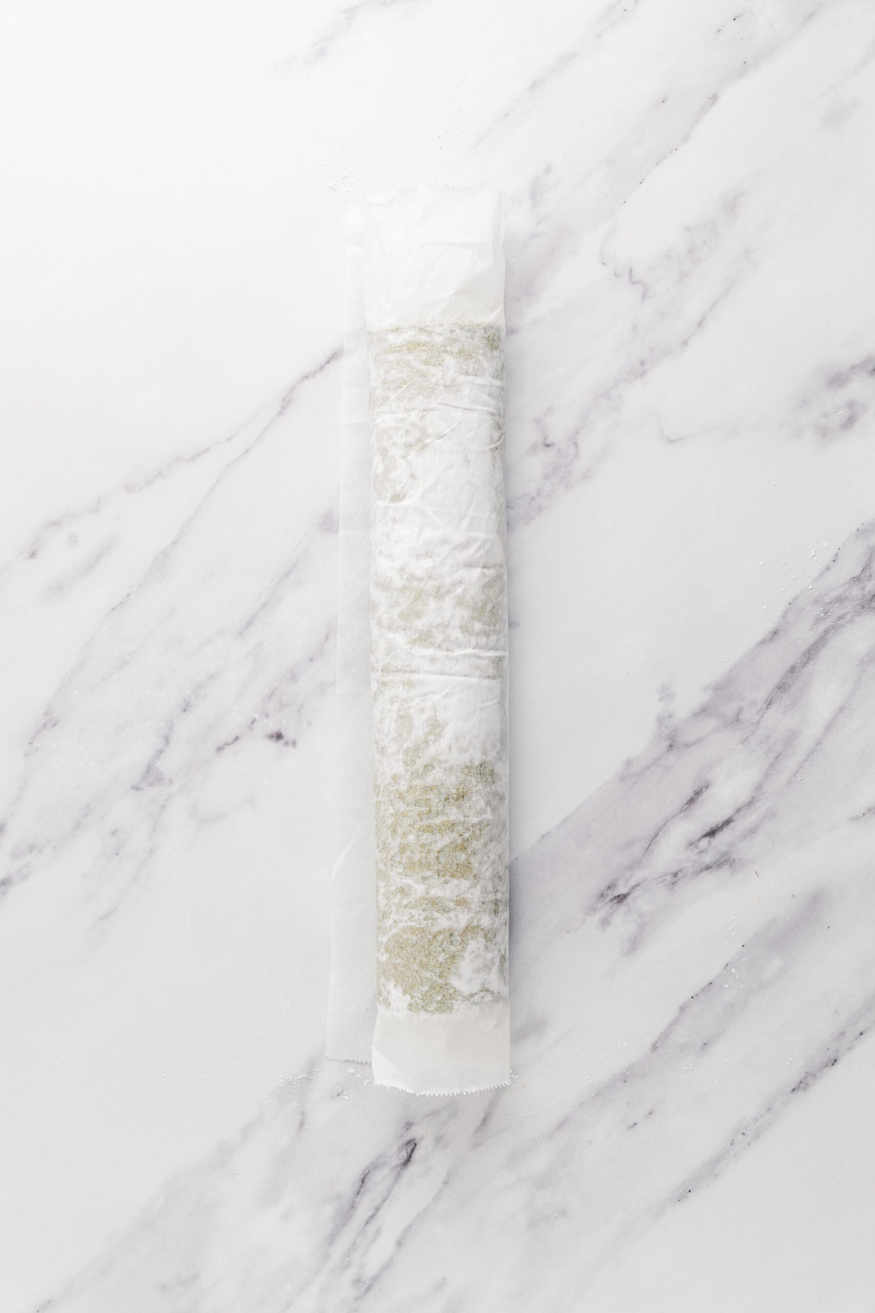 Rolling the sponge warm - Catherine Zhang Warm matcha sponge rolled up inside parchment to set its curve