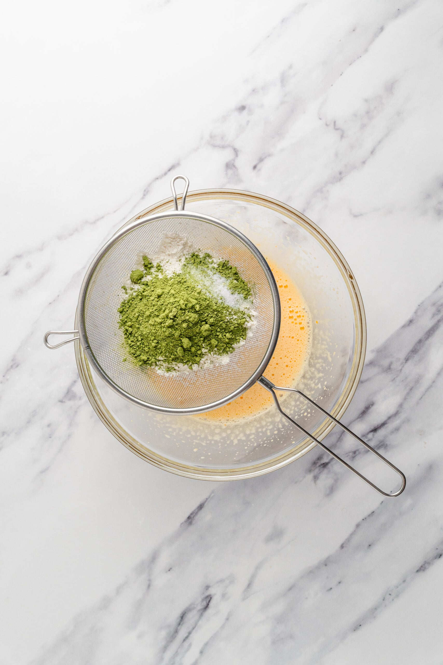 Sifting the matcha - Catherine Zhang Cake flour and matcha powder being sifted into the egg yolk batter