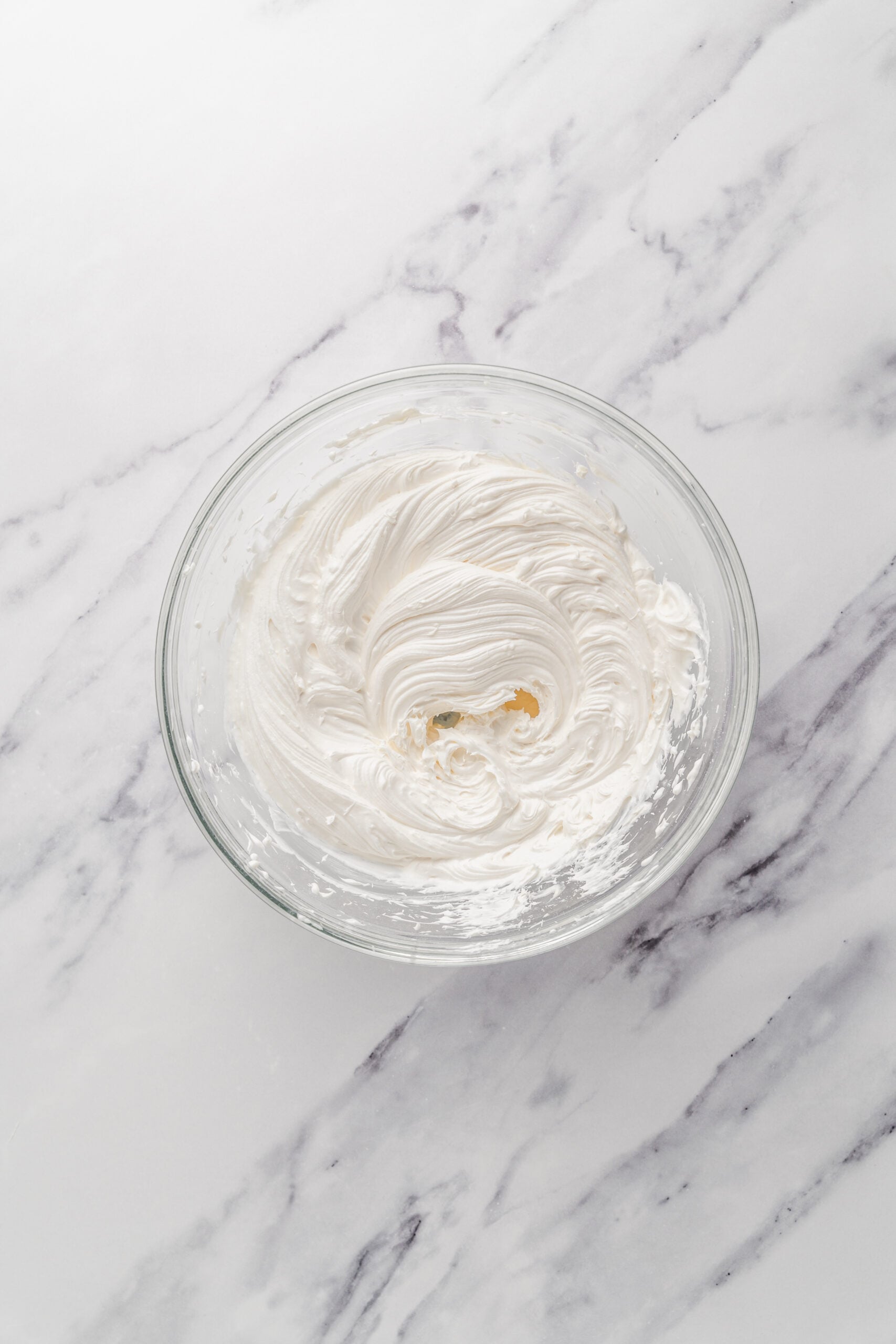 Whipped cream filling - Catherine Zhang Whipped cream and mascarpone beaten to firm peaks in a glass bowl