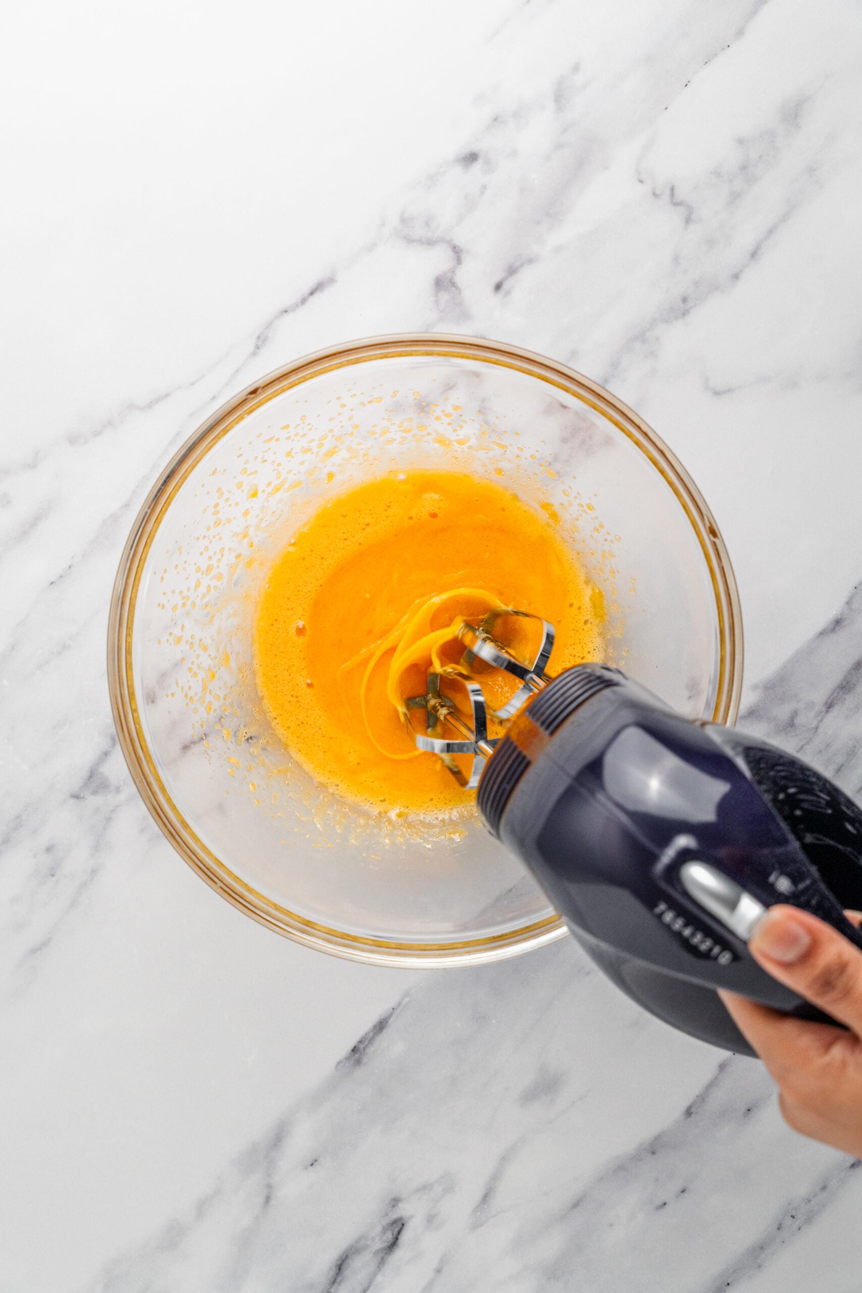 Whisking the egg yolks - Catherine Zhang Egg yolks and sugar being whisked pale with an electric mixer
