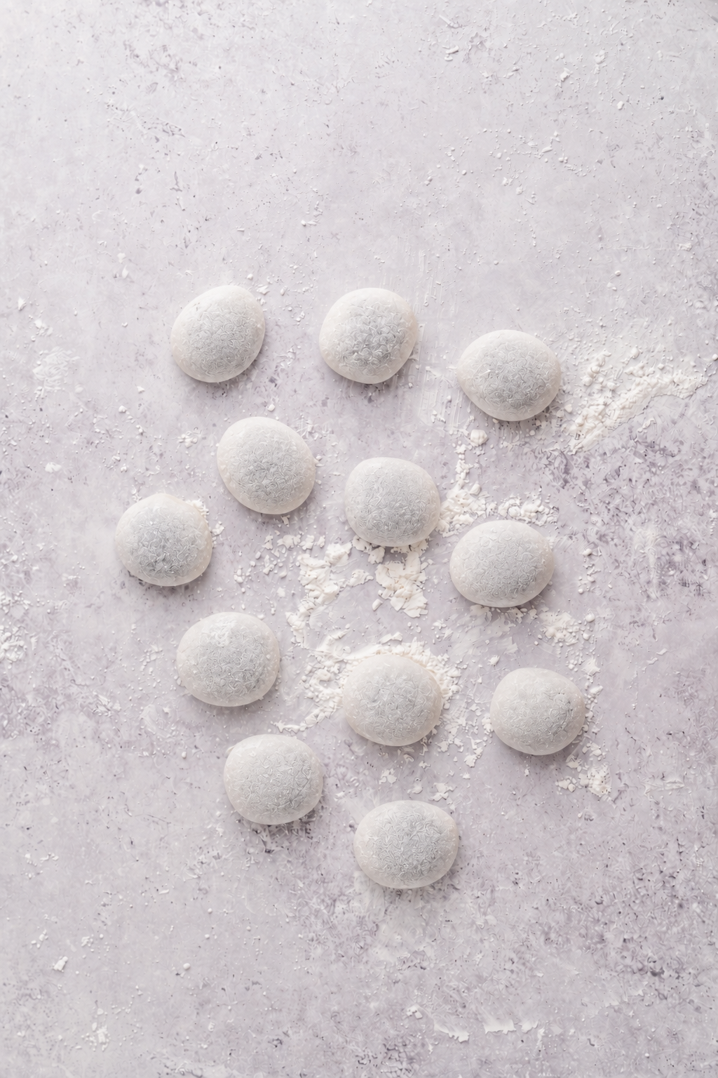 Mochi dough divided - Catherine Zhang Mochi dough divided into twelve dusted rounds ready to fill