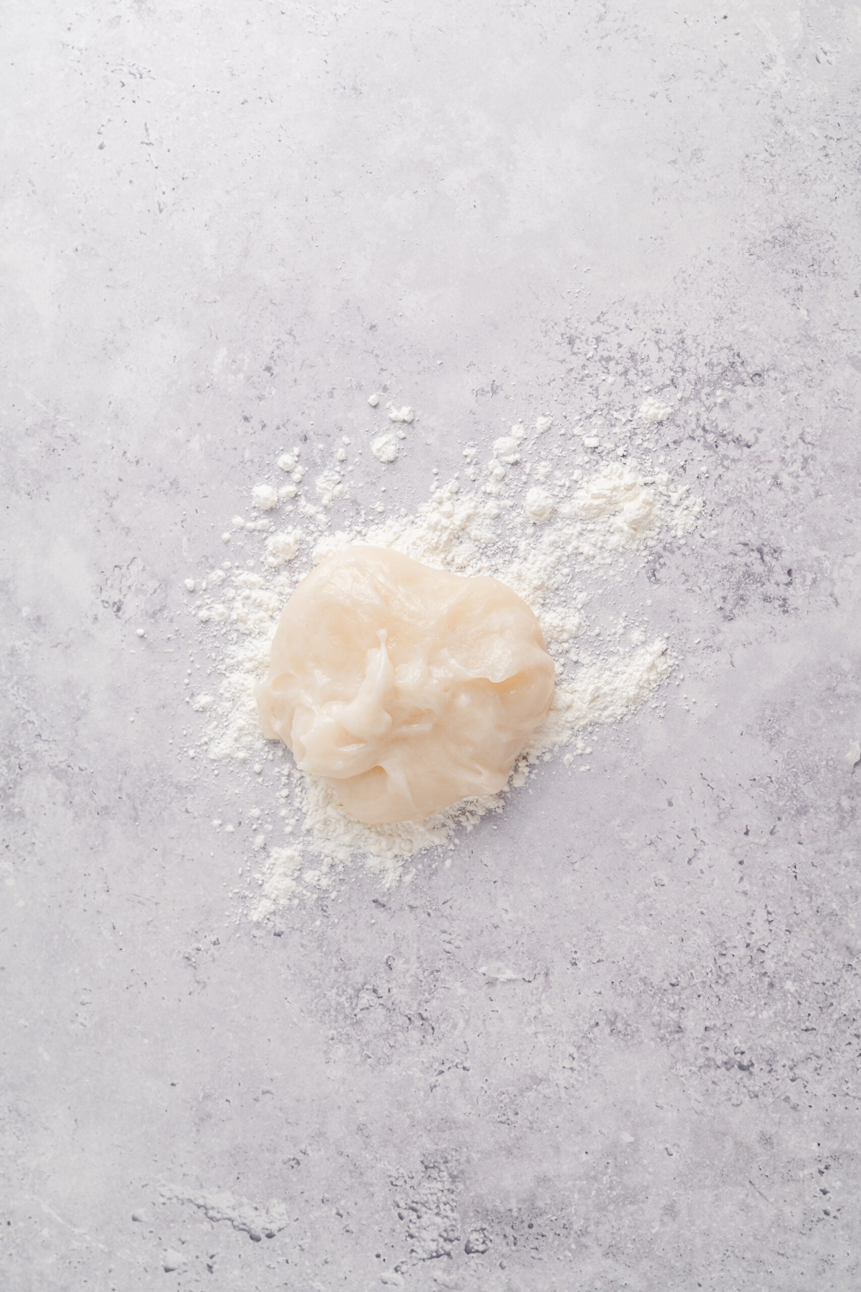 Mochi dough on the bench - Catherine Zhang Hot mochi dough turned out onto a starch dusted bench