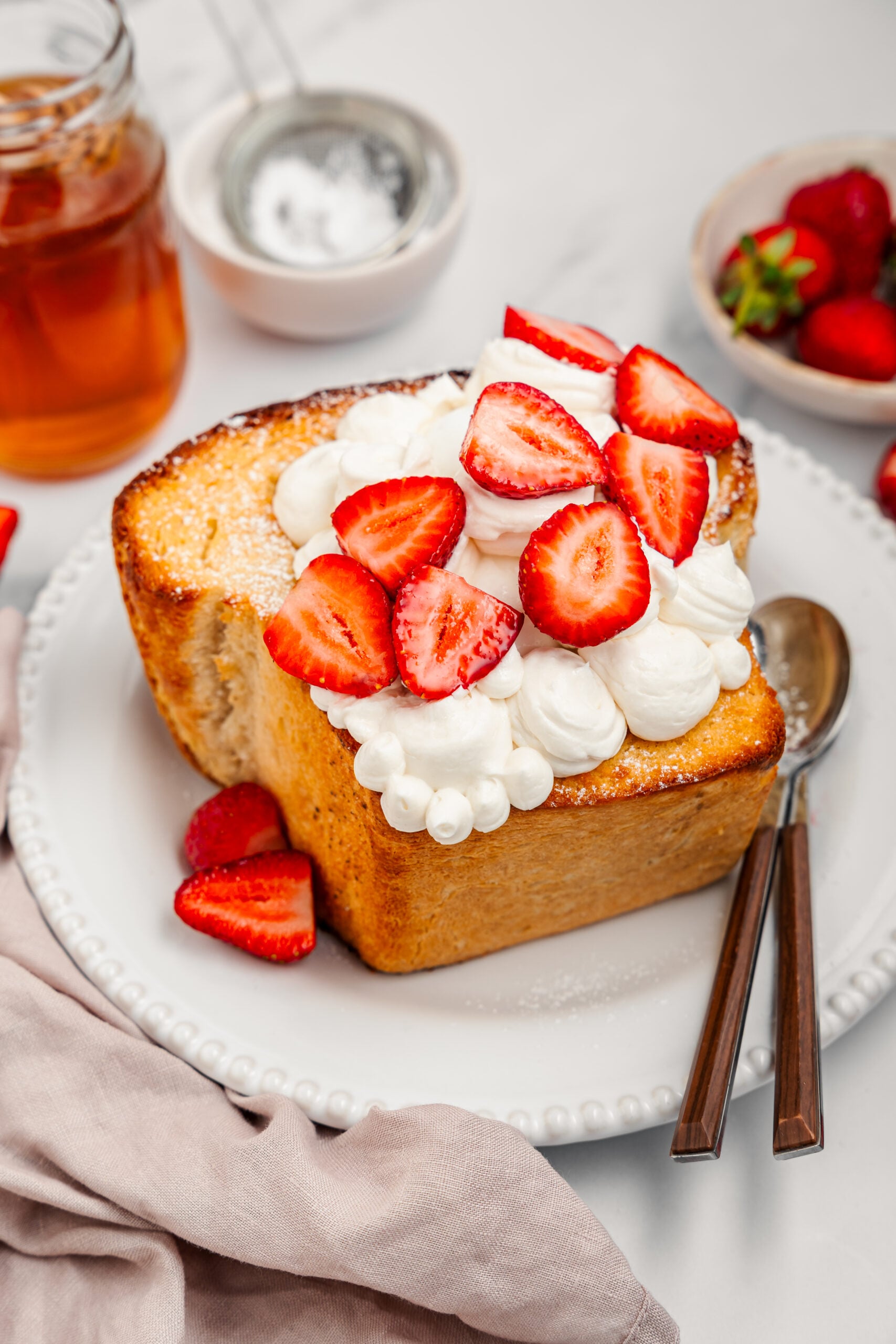 Shibuya Honey Toast - Catherine Zhang Shibuya honey toast topped with whipped cream and strawberries on a white plate