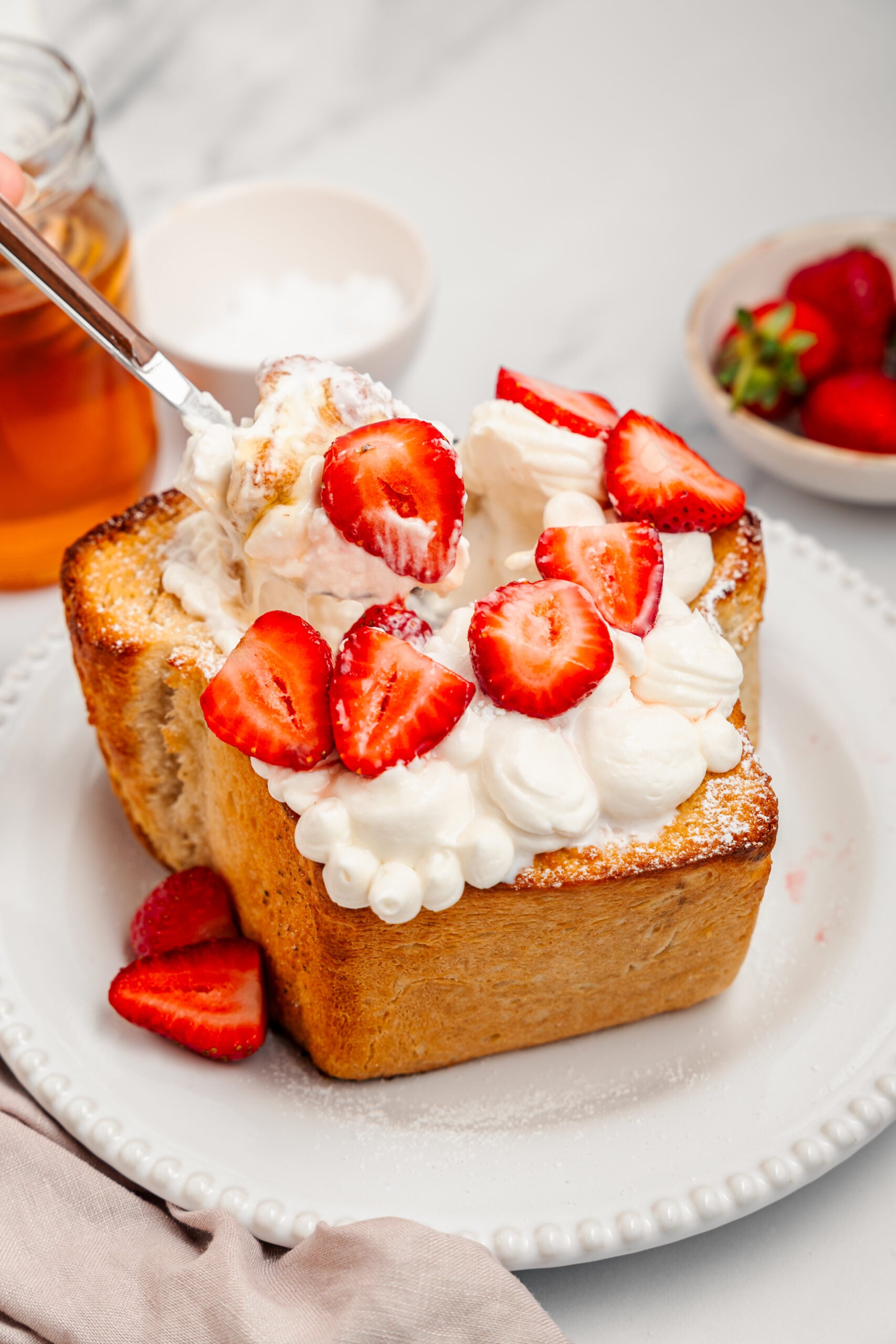 Shibuya Honey Toast - Catherine Zhang A spoon digging into Shibuya honey toast with whipped cream and ice cream