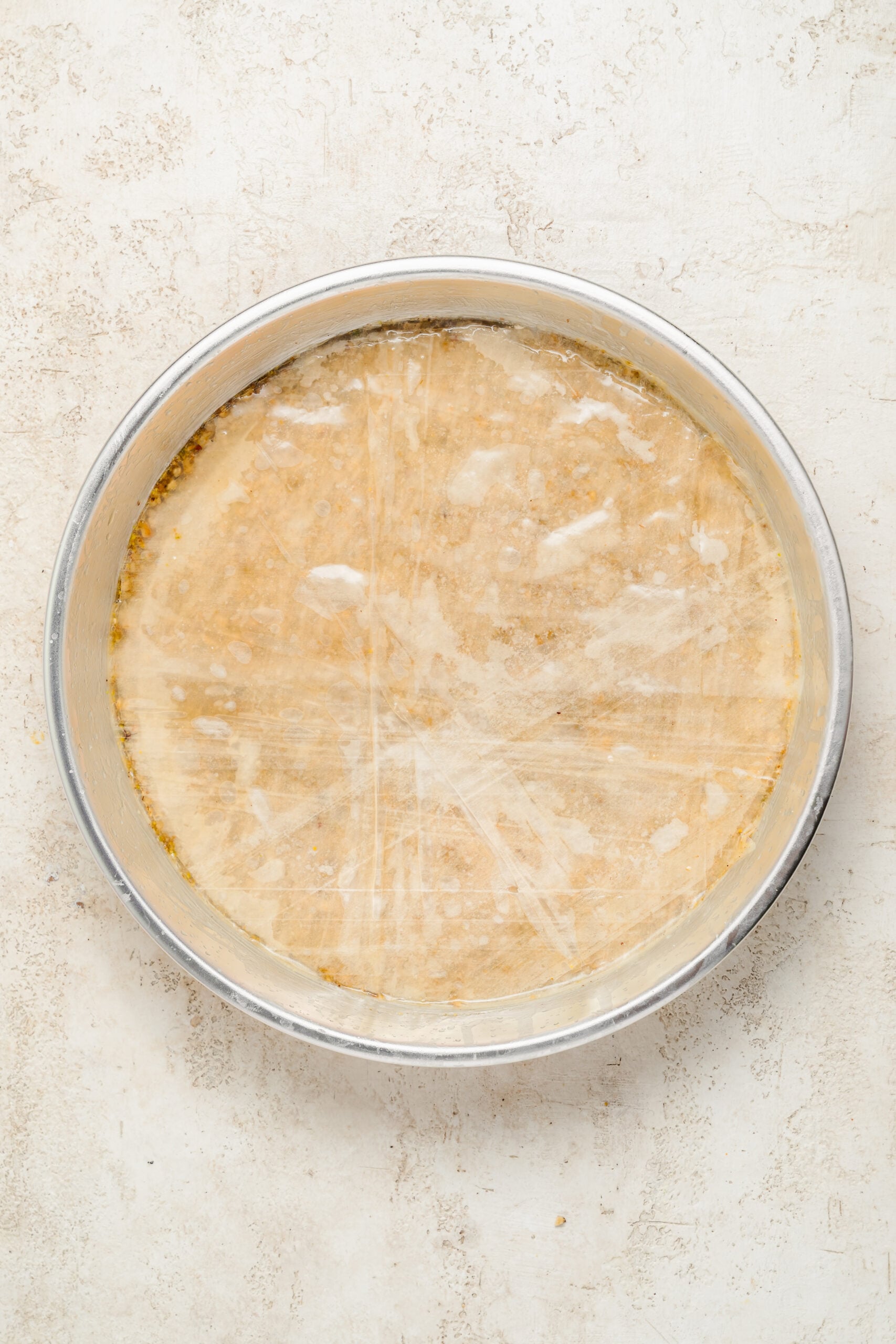Phyllo laid over the nut layer - Catherine Zhang Buttered phyllo sheets laid over the first nut layer of the baklava