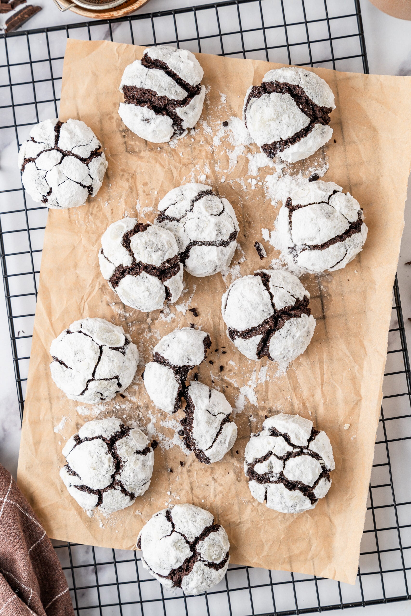 chocolate-crinkle-cookies-cooling-rack - Catherine Zhang Chocolate crinkle cookies cooling on parchment over a wire rack