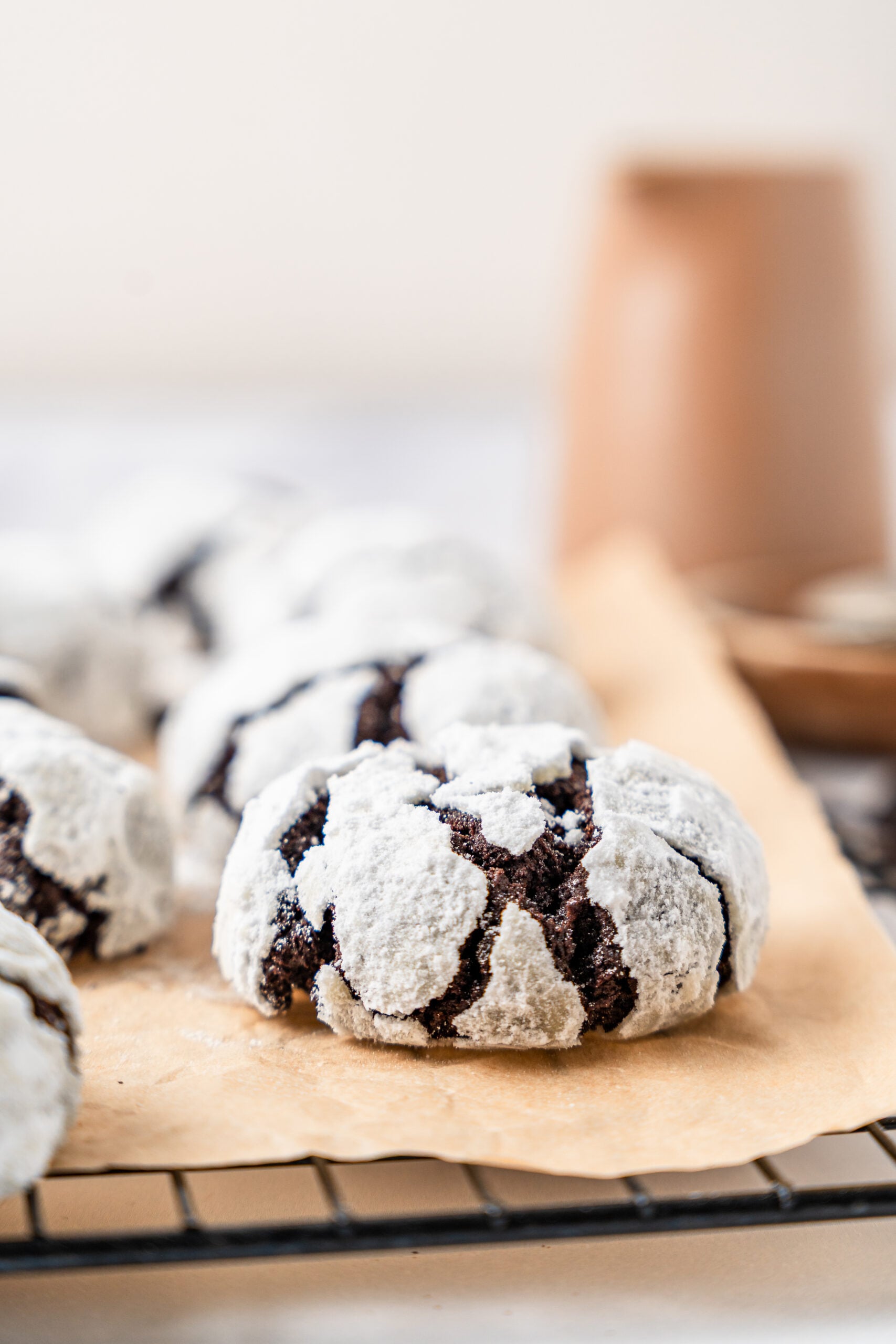 chocolate-crinkle-cookies-hero - Catherine Zhang Chocolate crinkle cookies with a thick white crackled sugar crust on parchment