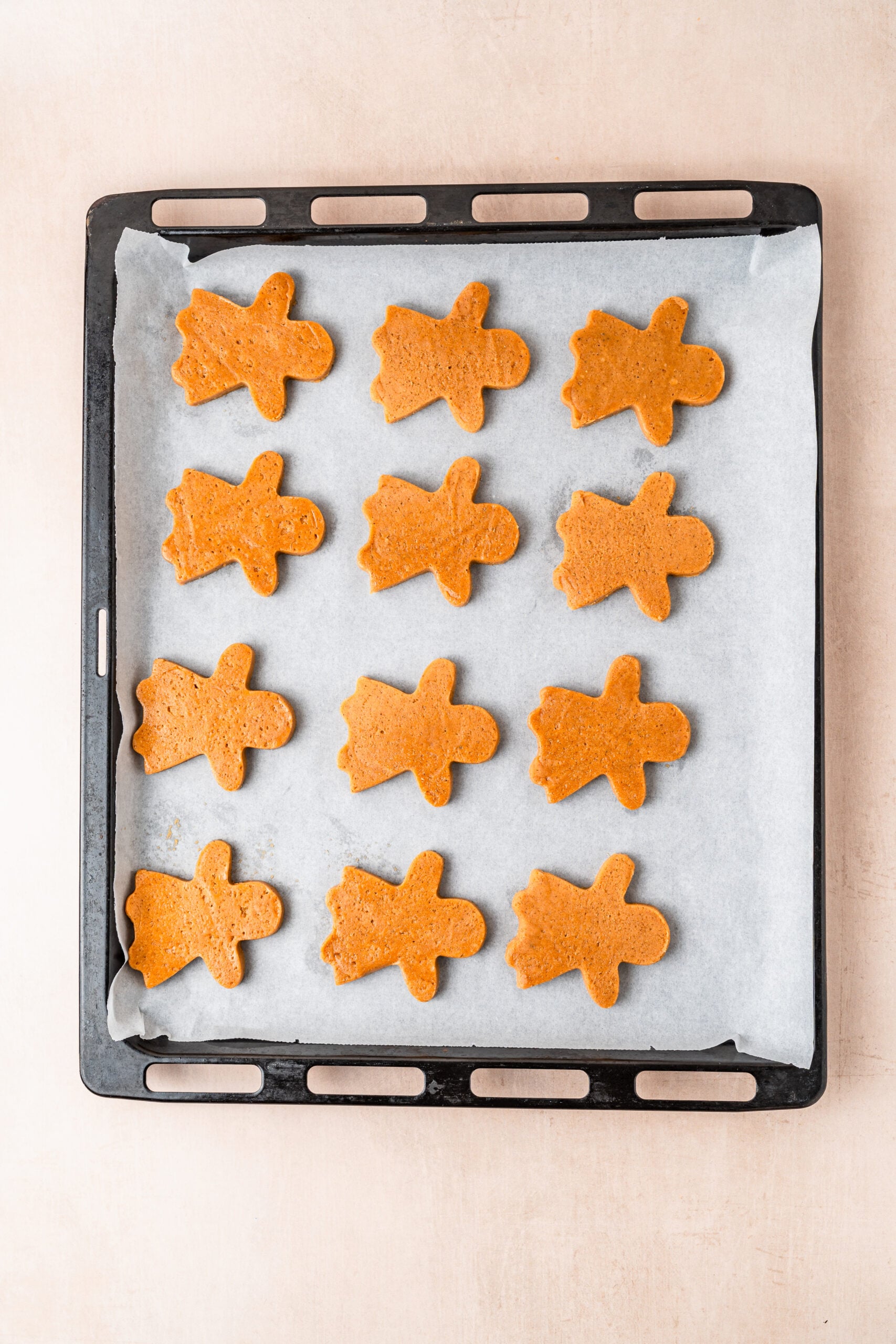 gingerbread-cookies-baked-on-tray - Catherine Zhang Baked gingerbread cookies on a lined tray with clean sharp edges and an even bronze colour
