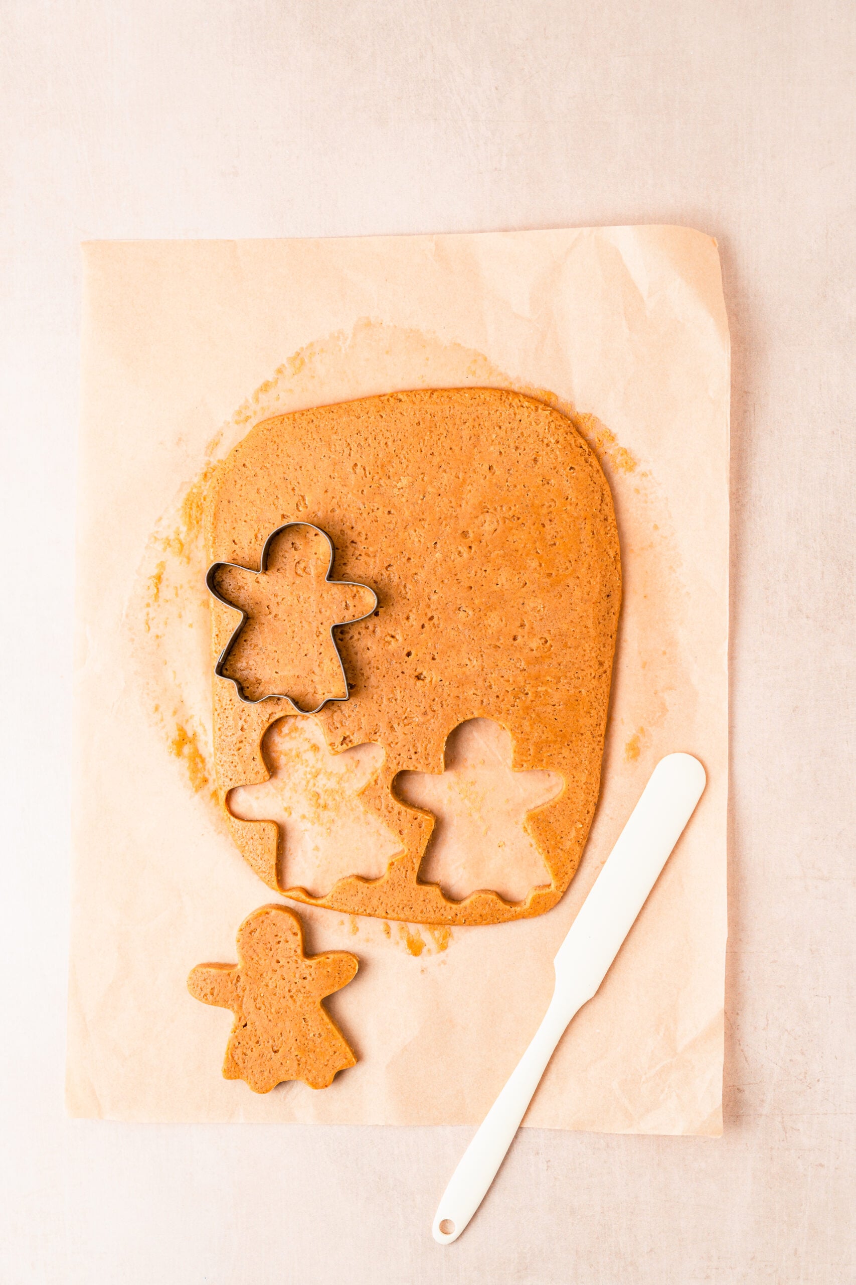 gingerbread-cookies-cutting-shapes - Catherine Zhang Gingerbread men cut from the rolled dough and lifted with a thin palette knife