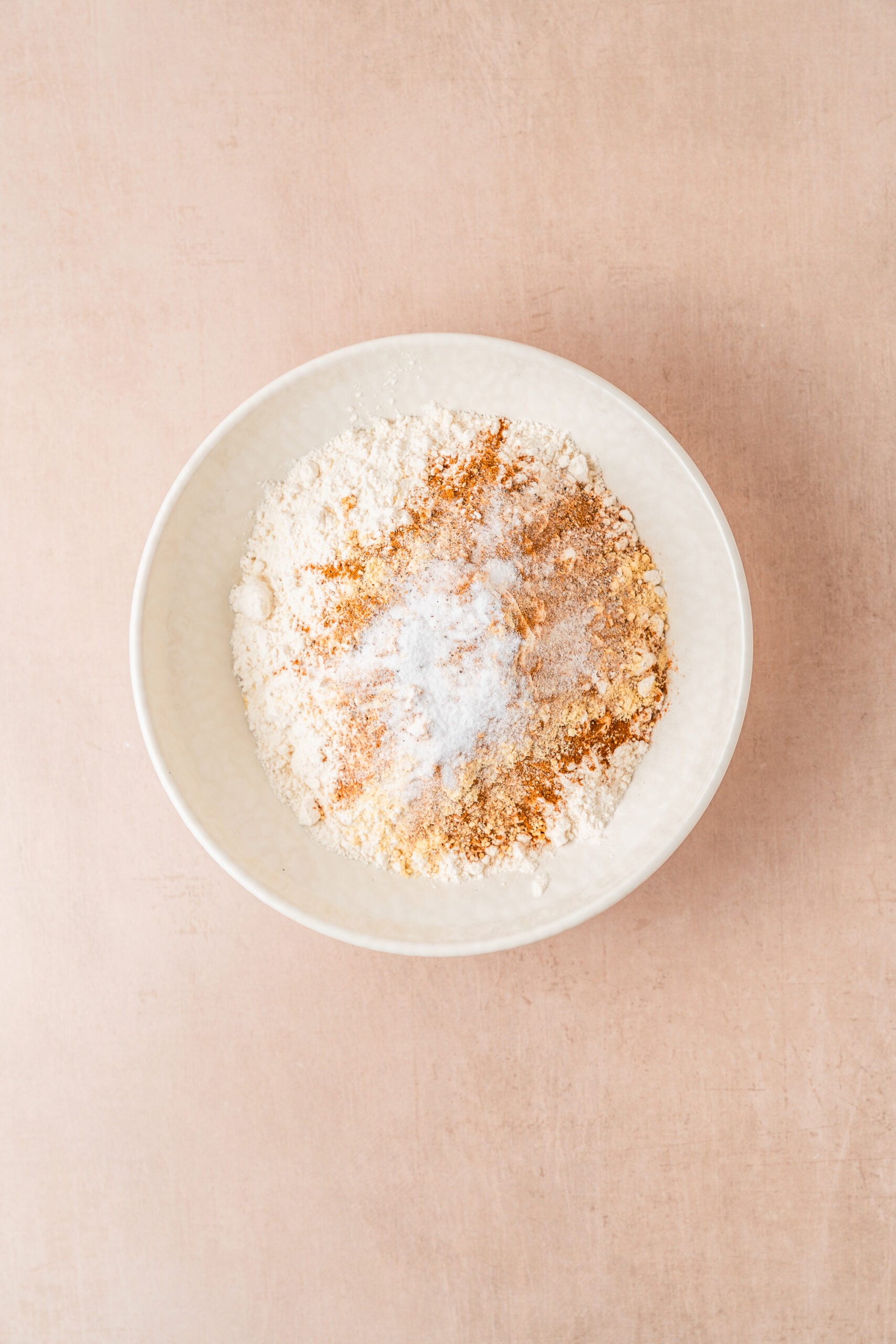 gingerbread-cookies-dry-ingredients-and-spices - Catherine Zhang Flour, ground ginger, cinnamon, cloves, nutmeg and bicarbonate of soda in a bowl for gingerbread cookies