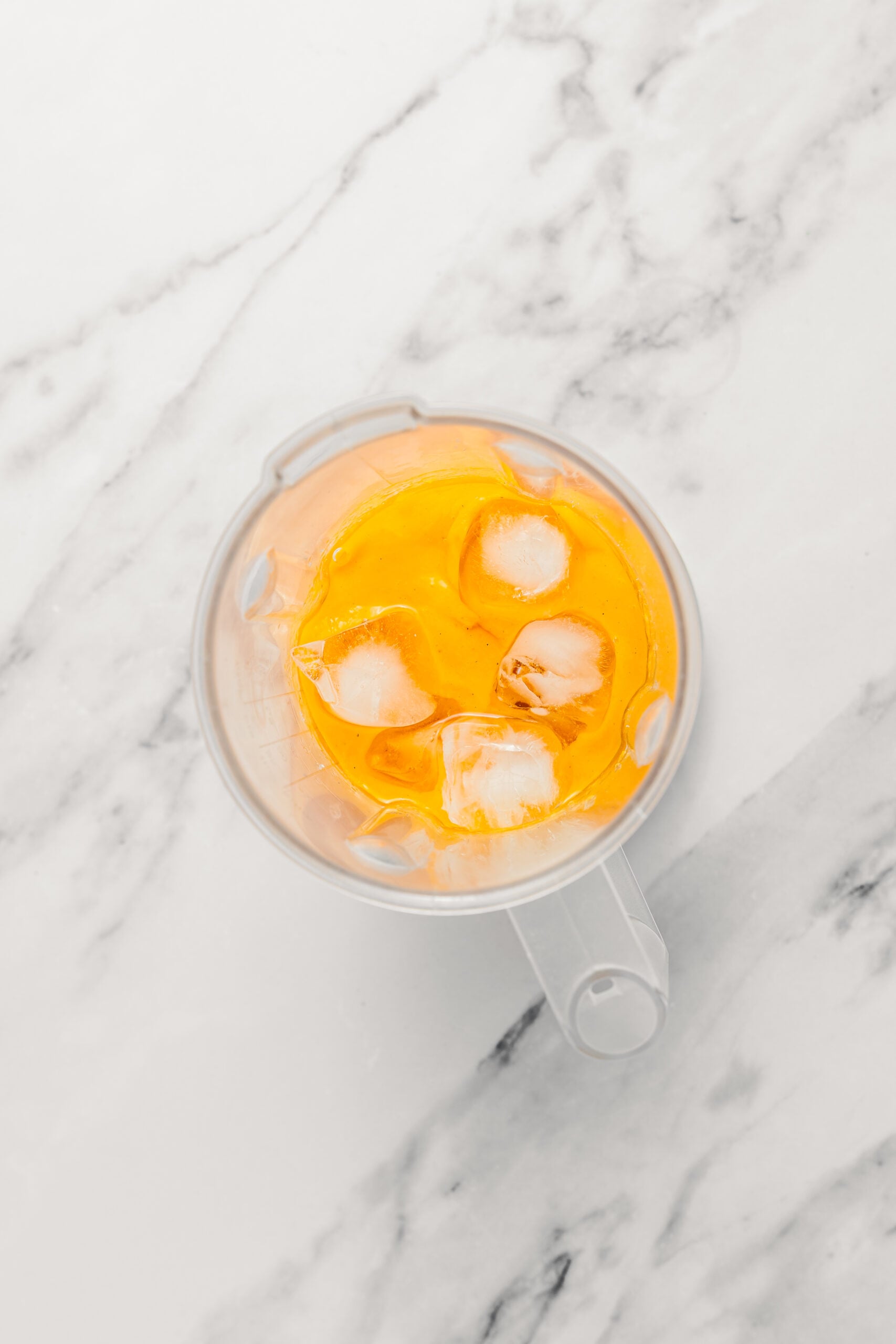Adding ice to the mango puree - Catherine Zhang Ice cubes added to the mango puree in the blender jug