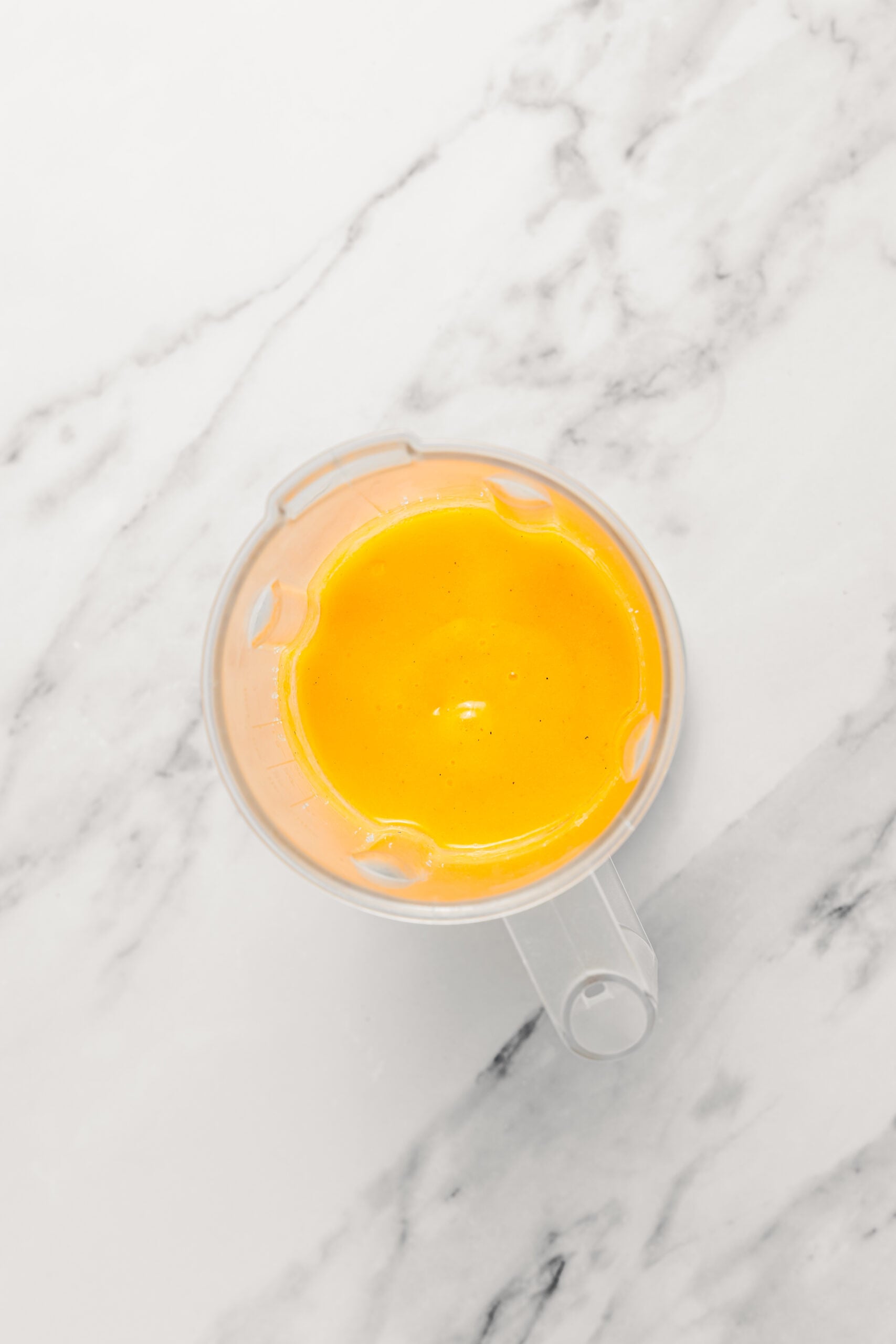 Mango puree blended with ice - Catherine Zhang Mango puree blended smooth with ice in the blender jug