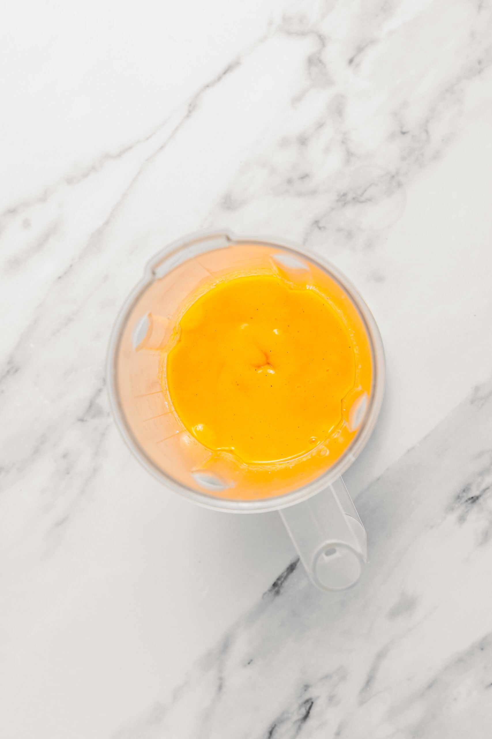 Smooth mango puree - Catherine Zhang Smooth bright orange mango puree in the blender jug
