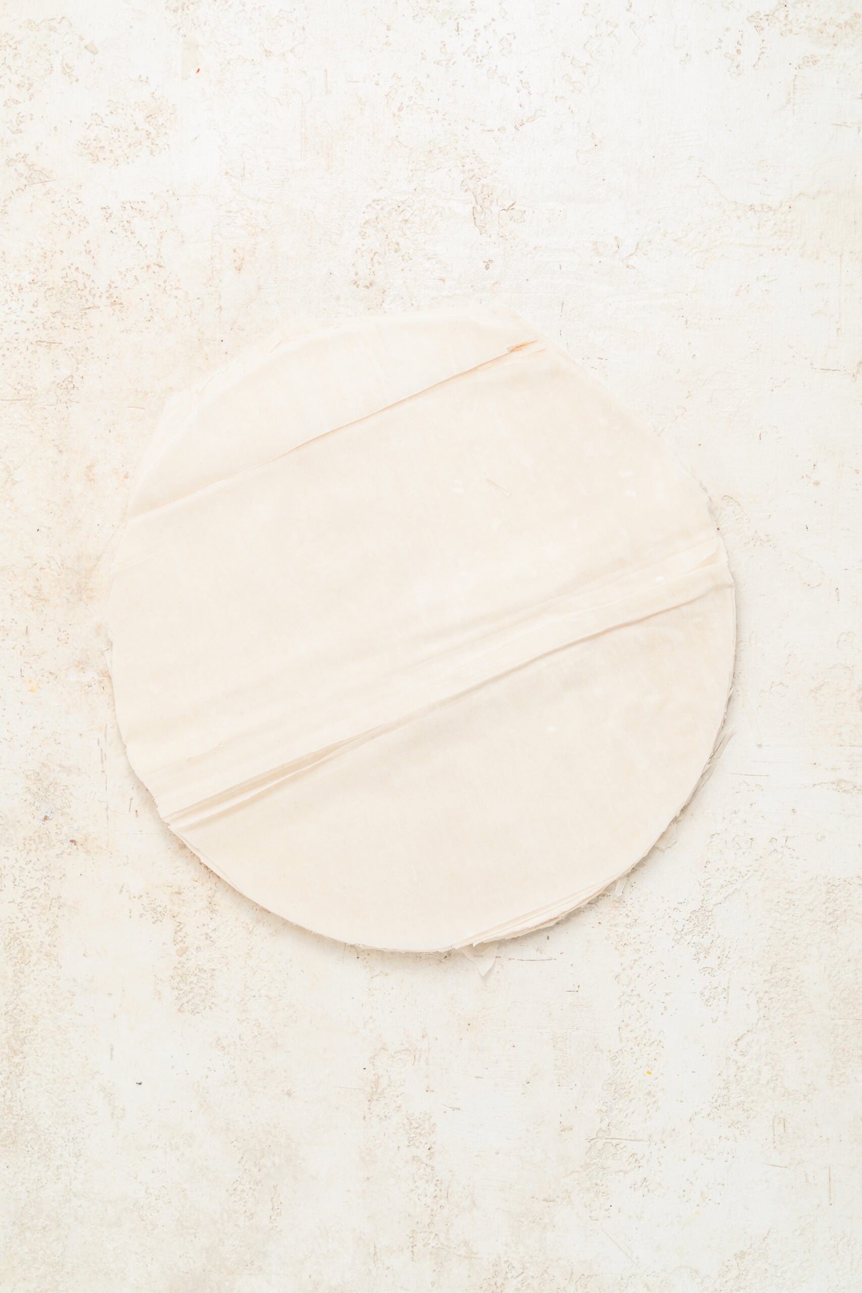 Phyllo pastry trimmed to the tin - Catherine Zhang A stack of phyllo pastry sheets trimmed to fit the baking tin