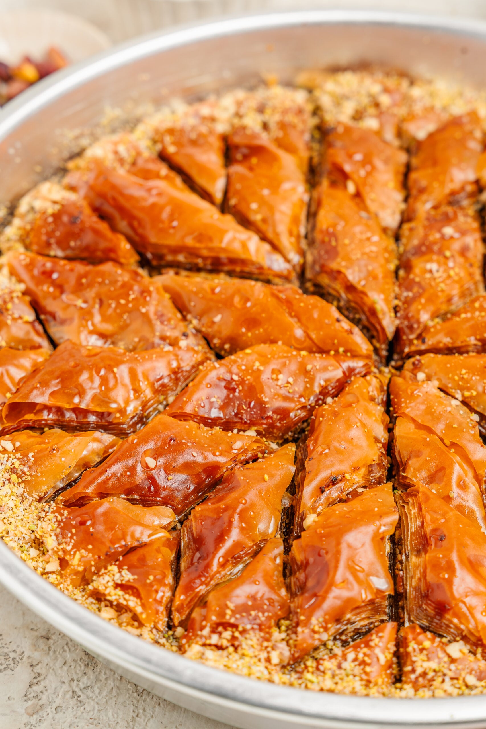 Pistachio baklava diamonds in the tin - Catherine Zhang Pistachio baklava diamonds in the tin with chopped nuts around the edge
